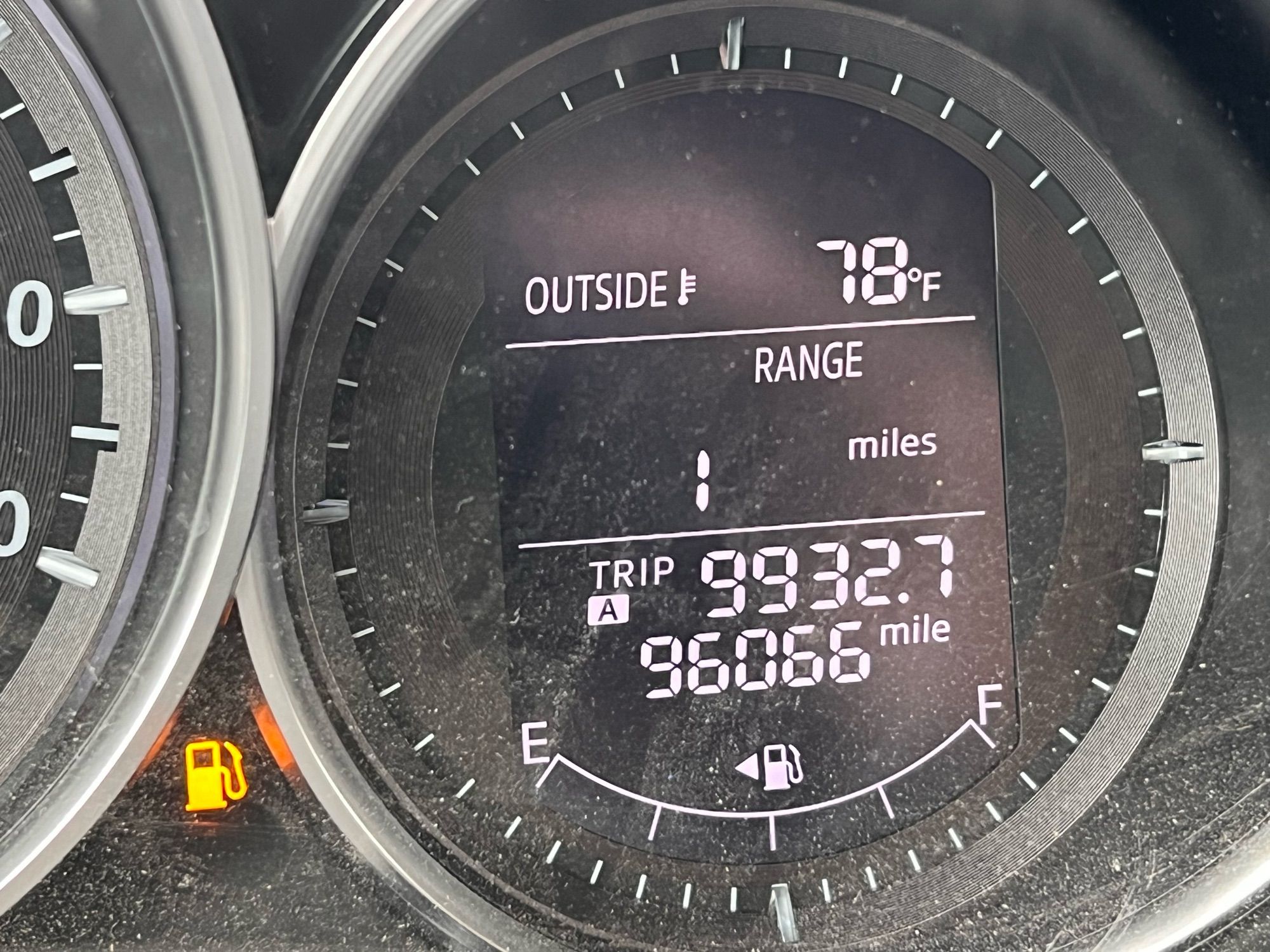 Photograph of a car dashboard gas gauge at empty, with 1 mile range left