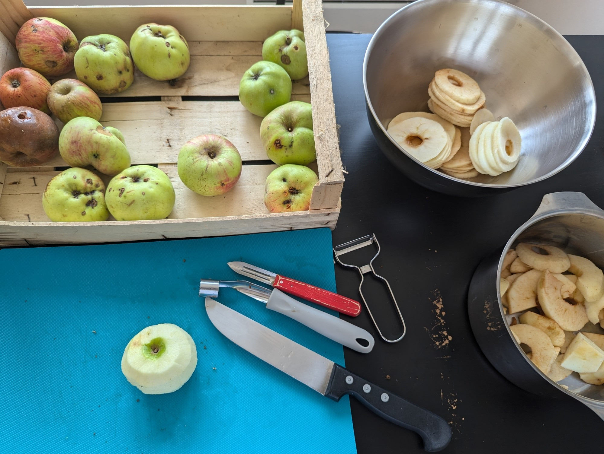 Un cageot de pomme en cours d'épluchage : les belles rondelles seront séchées, les autres morceaux feront de la compote