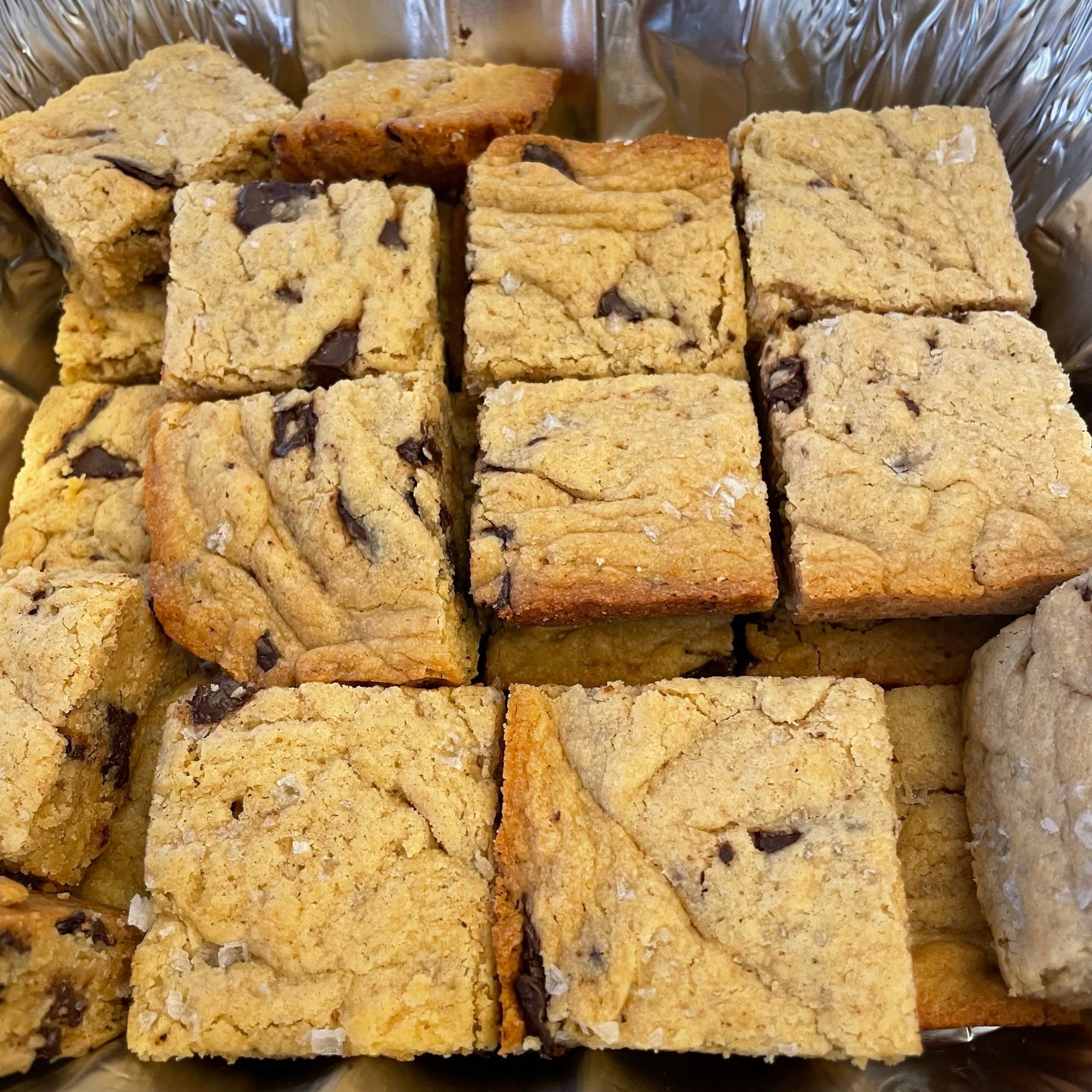 Aluminum pan containing chocolate chunk tahini Blondie bars.