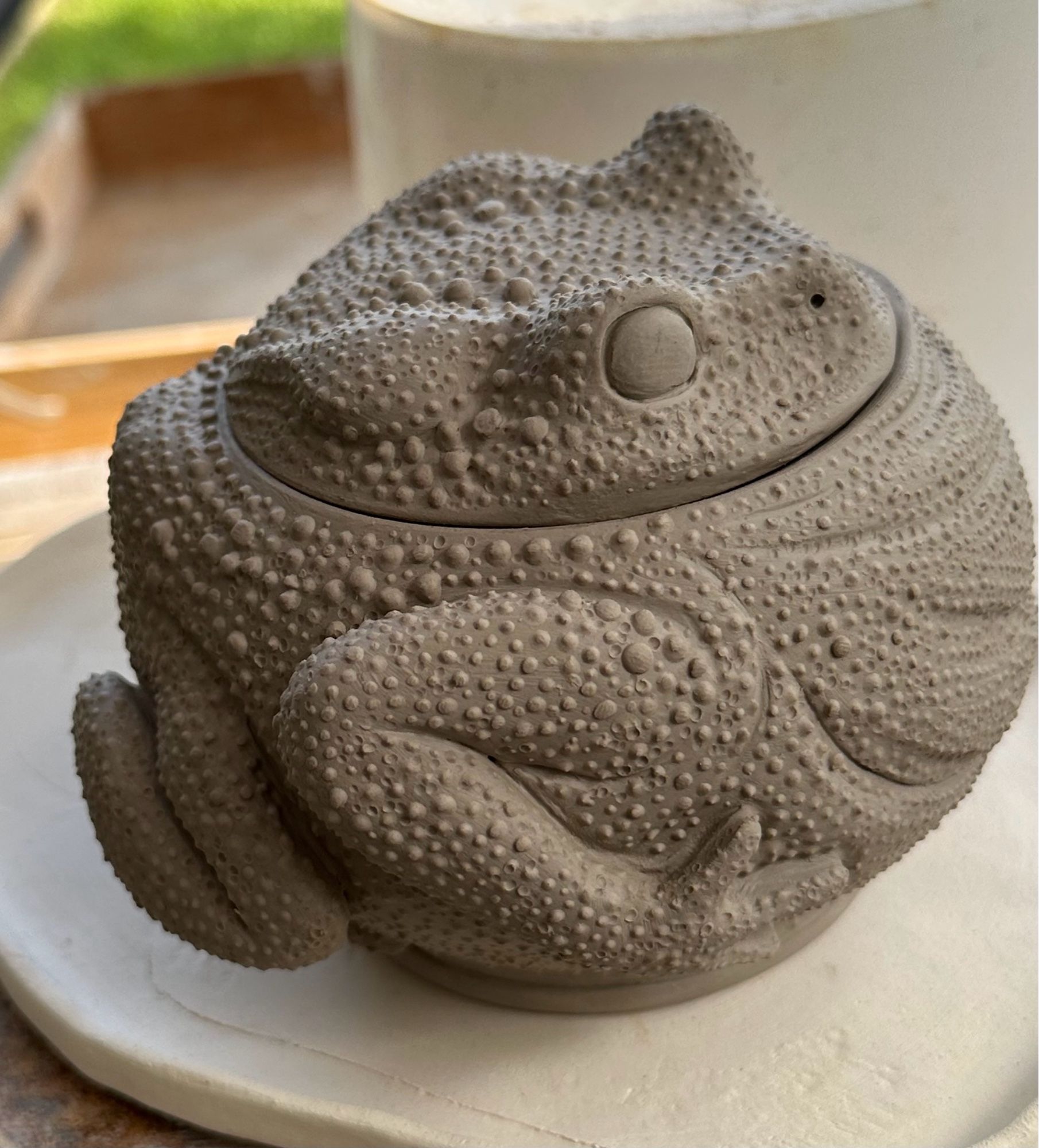 Unfinished ceramic lidded pot in the shape of a round toad