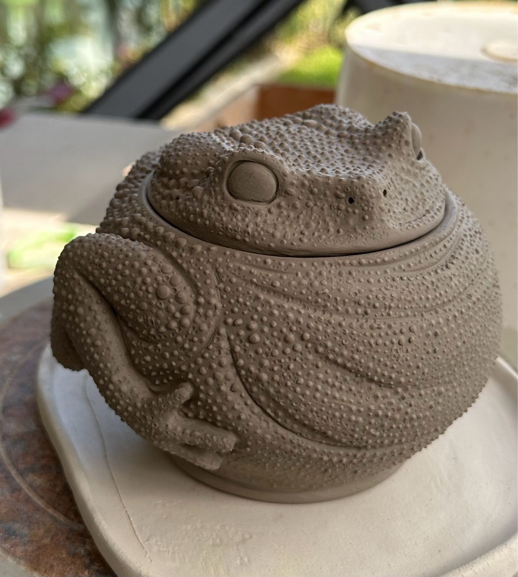 Unfinished ceramic lidded pot in the shape of a round toad