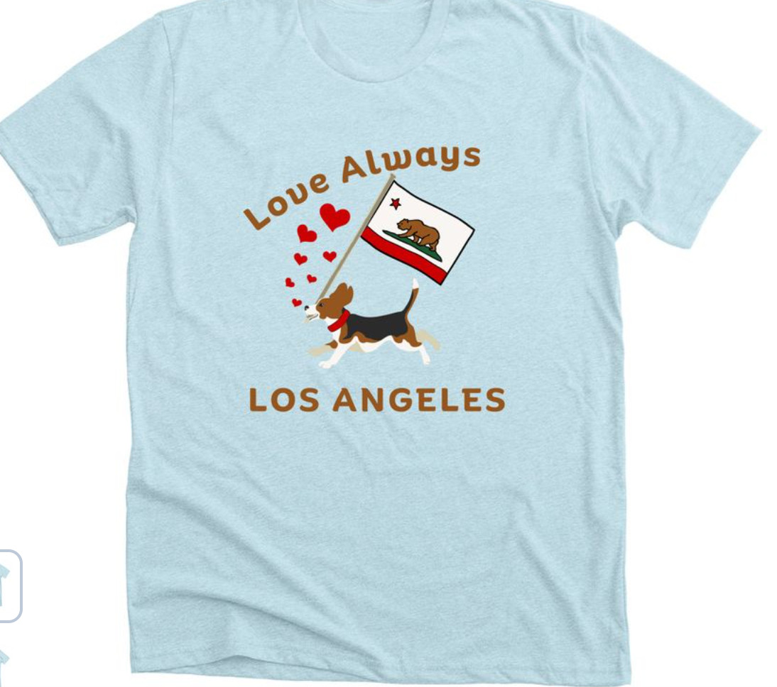 A picture of the Beagle Tee shirt--which is light blue, the graphic is the beagle running through some red hearts while carrying a California Flag in his mouth, and the text says Love Always above the beagle and Los Angeles below the beagle. There are many sizes and different styles at the link. 