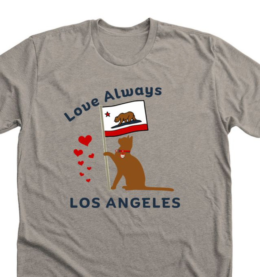 A picture of the Cat Tee shirt--which is a very light brown, sort of like latte colored, the graphic is the brown cat with some red hearts while holding a California Flag and the text says Love Always above the beagle and Los Angeles below the cat. There are many sizes and different styles at the link. 