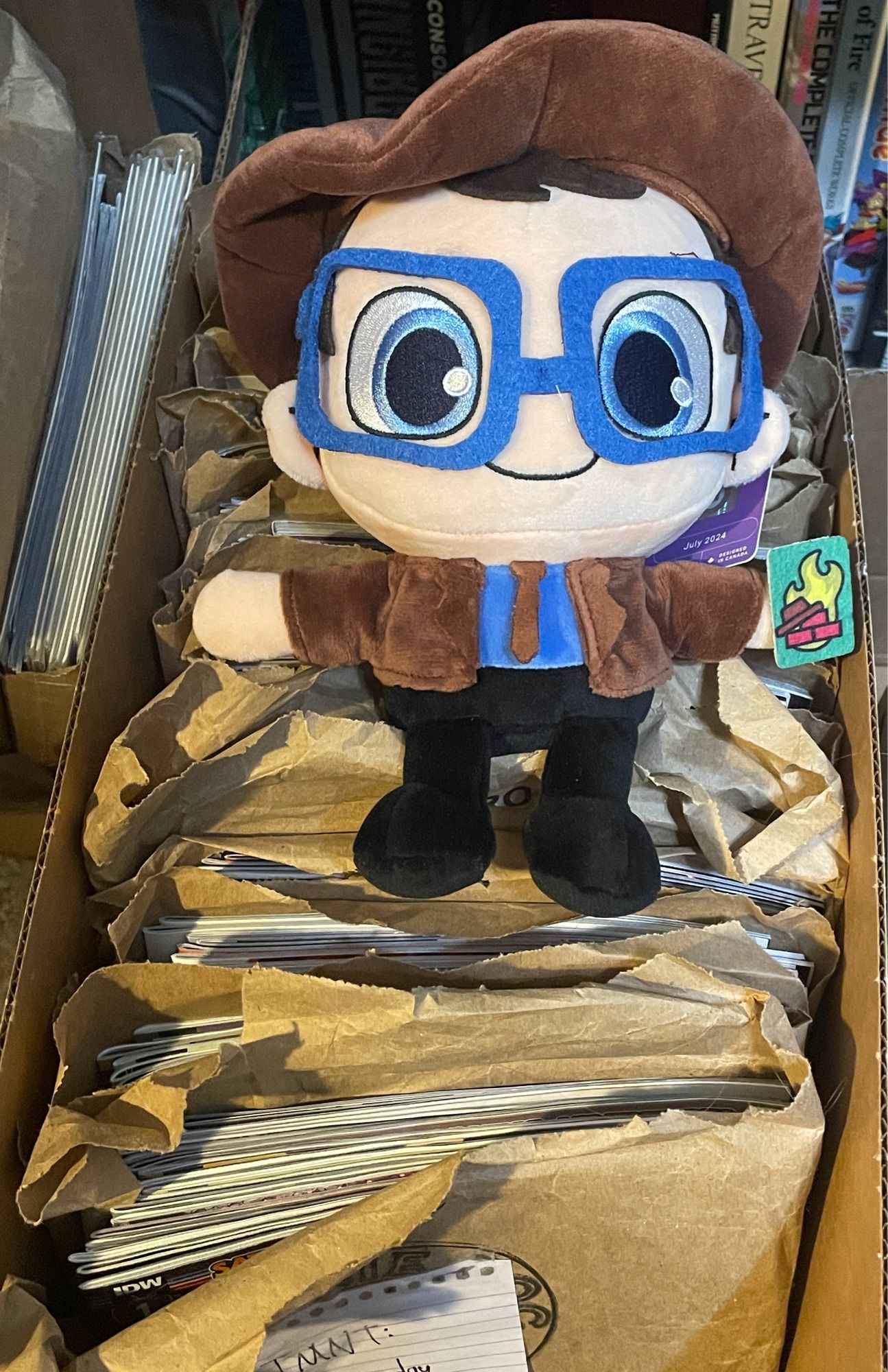 Linkara plush from Makeship sitting atop not the fourth wall but rather a box of comic books issues.