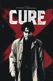 Kōji Yakusho as Kenichi Takabe looks pensive as he stands in front of a large red X on the movie poster for Cure