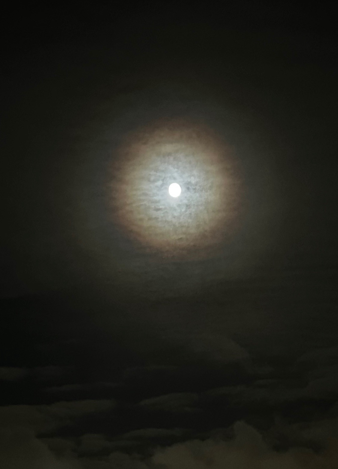 pretty moon in sky, halo effect all around it, clouds surrounding it 