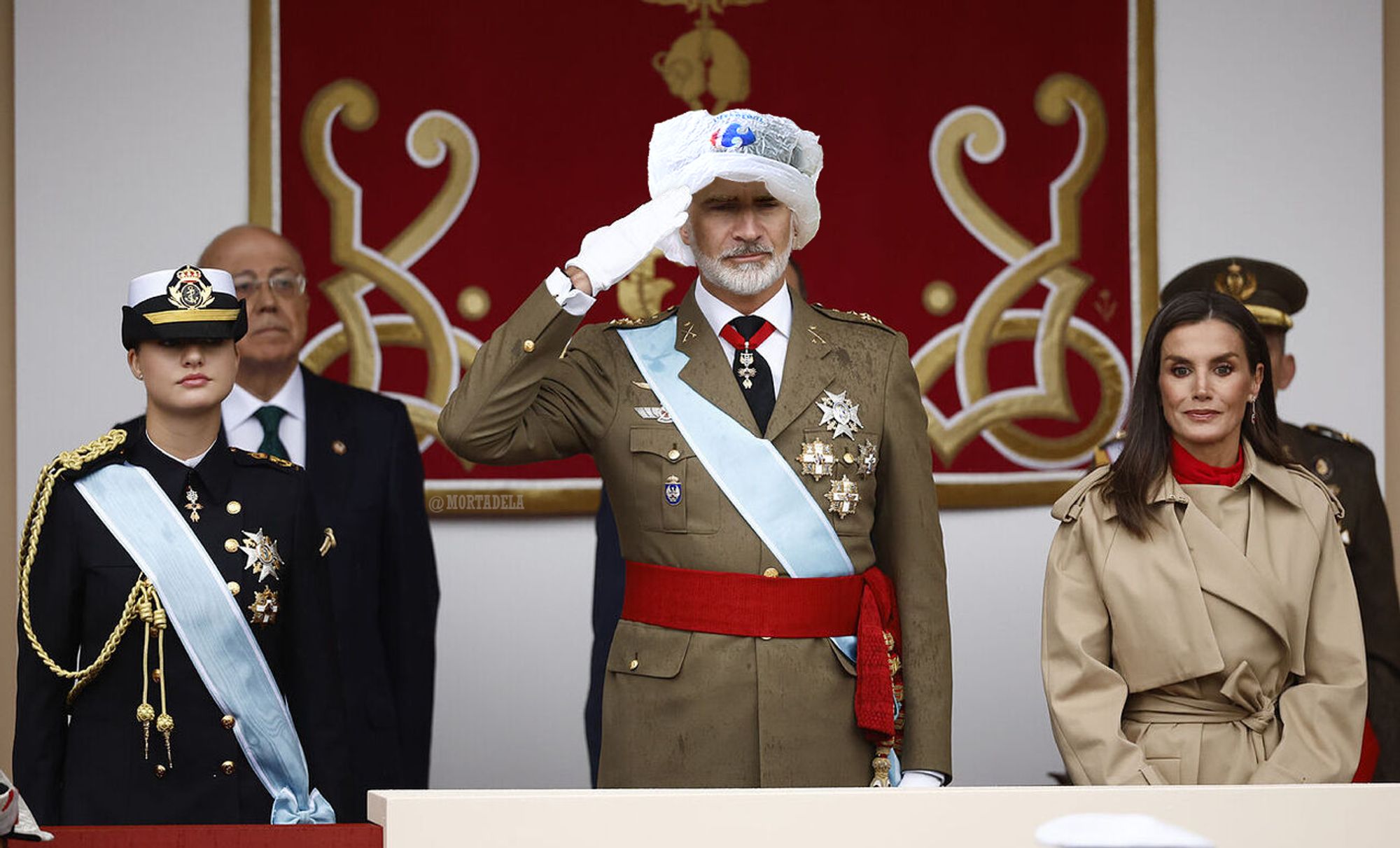 Tribuna de los reyes en el desfile del 12-O con Felipe UvePalito con una bolsa del Carrefour en la cabeza.