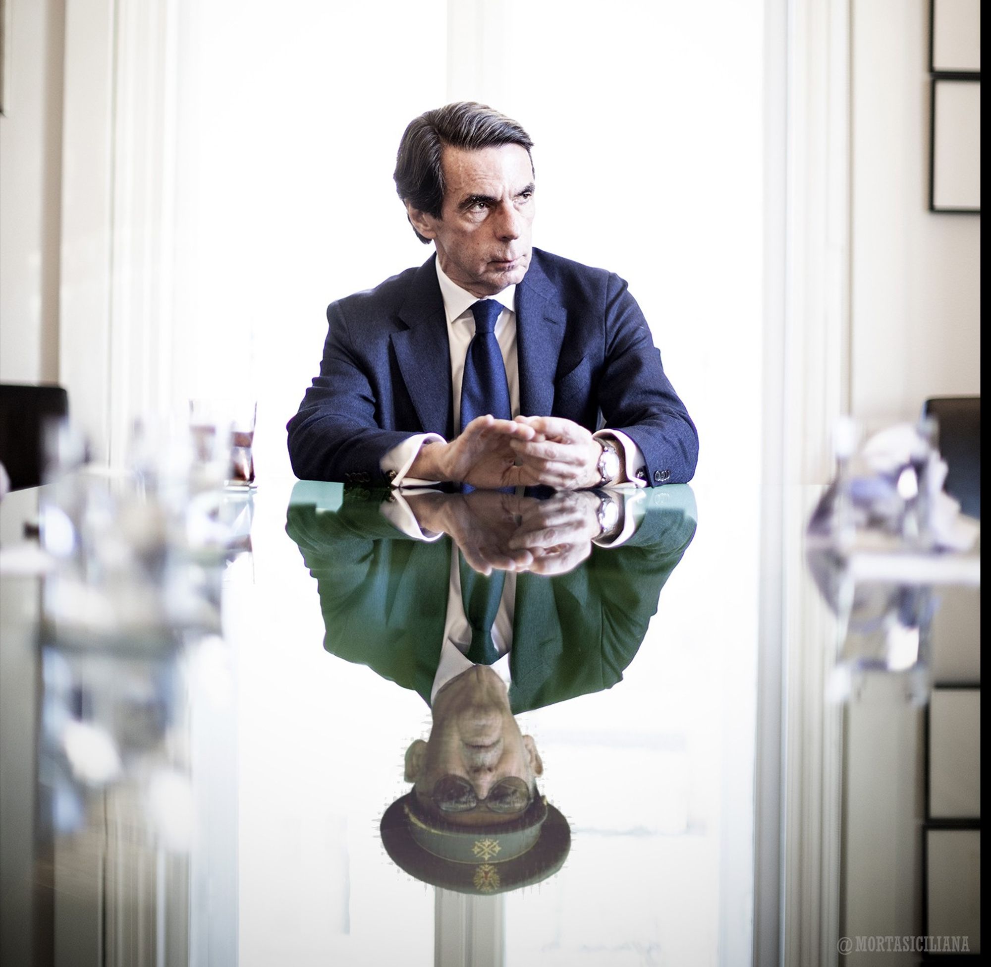 Aznar y su reflejo en una mesa con la cara de Paca la culona.