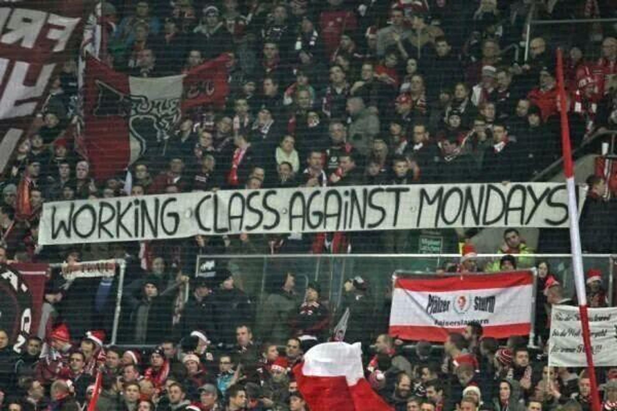 Imagen de grada en partido de fútbol con pancarta que dice: "Working class against mondays".