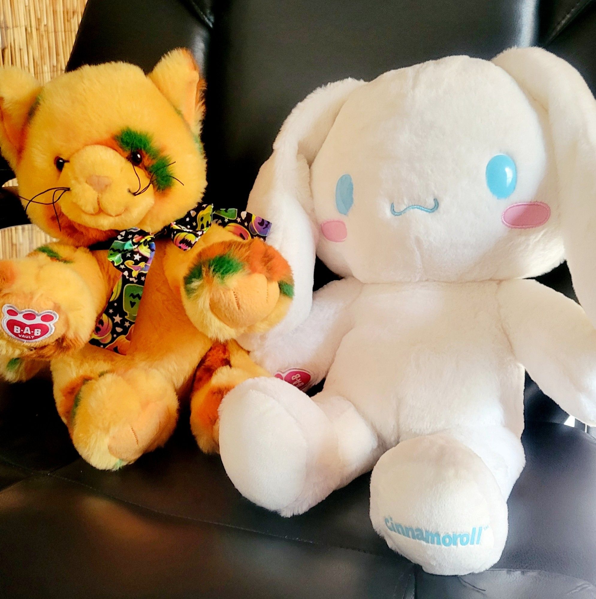 A picture of two Build-A-Bear stuffed animals, the one on the left being an orange pumpkin cat. The one on the right is a white bunny, with the name Cinnamonroll from Sanrio.