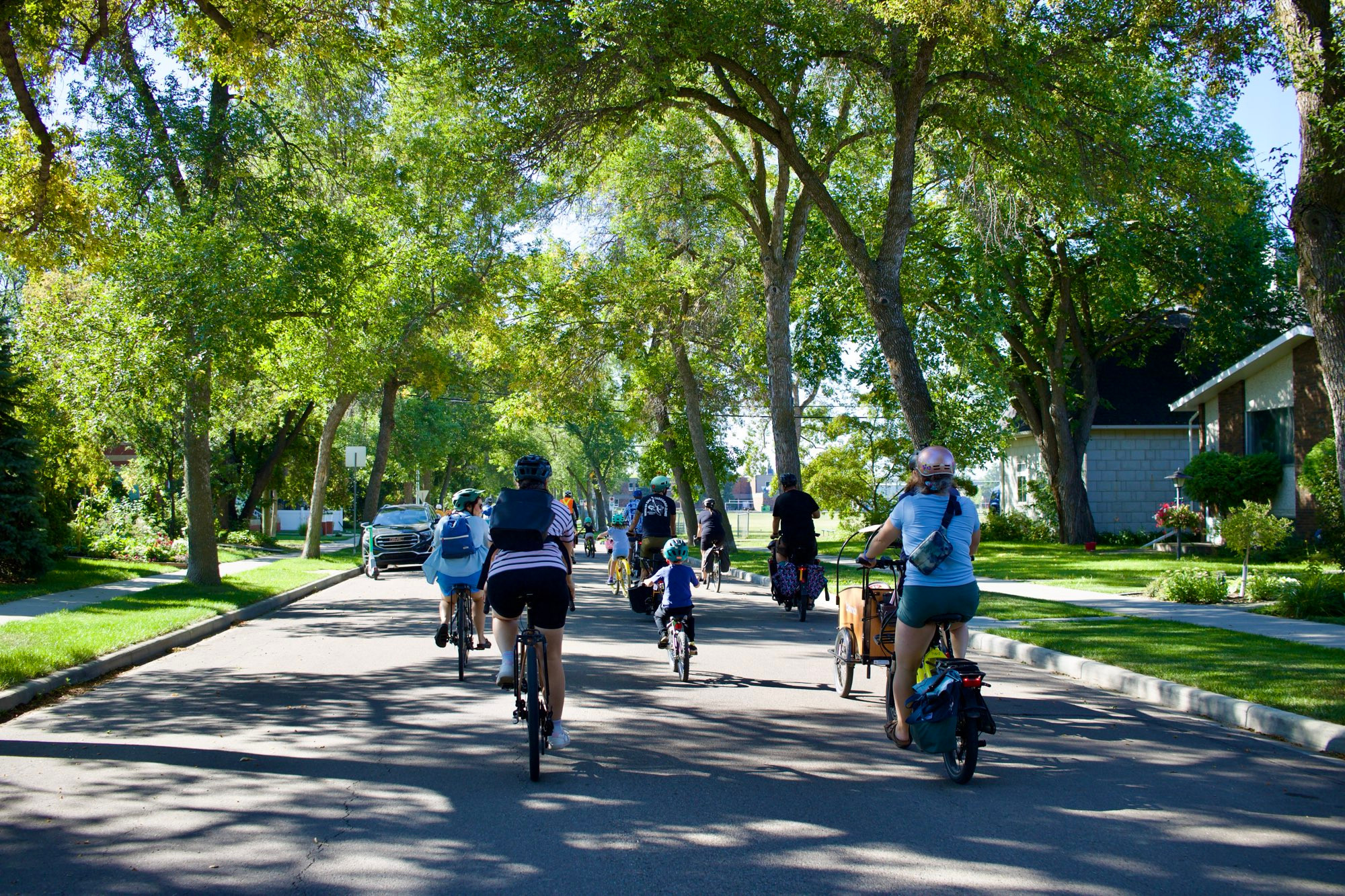 Group of children and adults riding bikes. 
