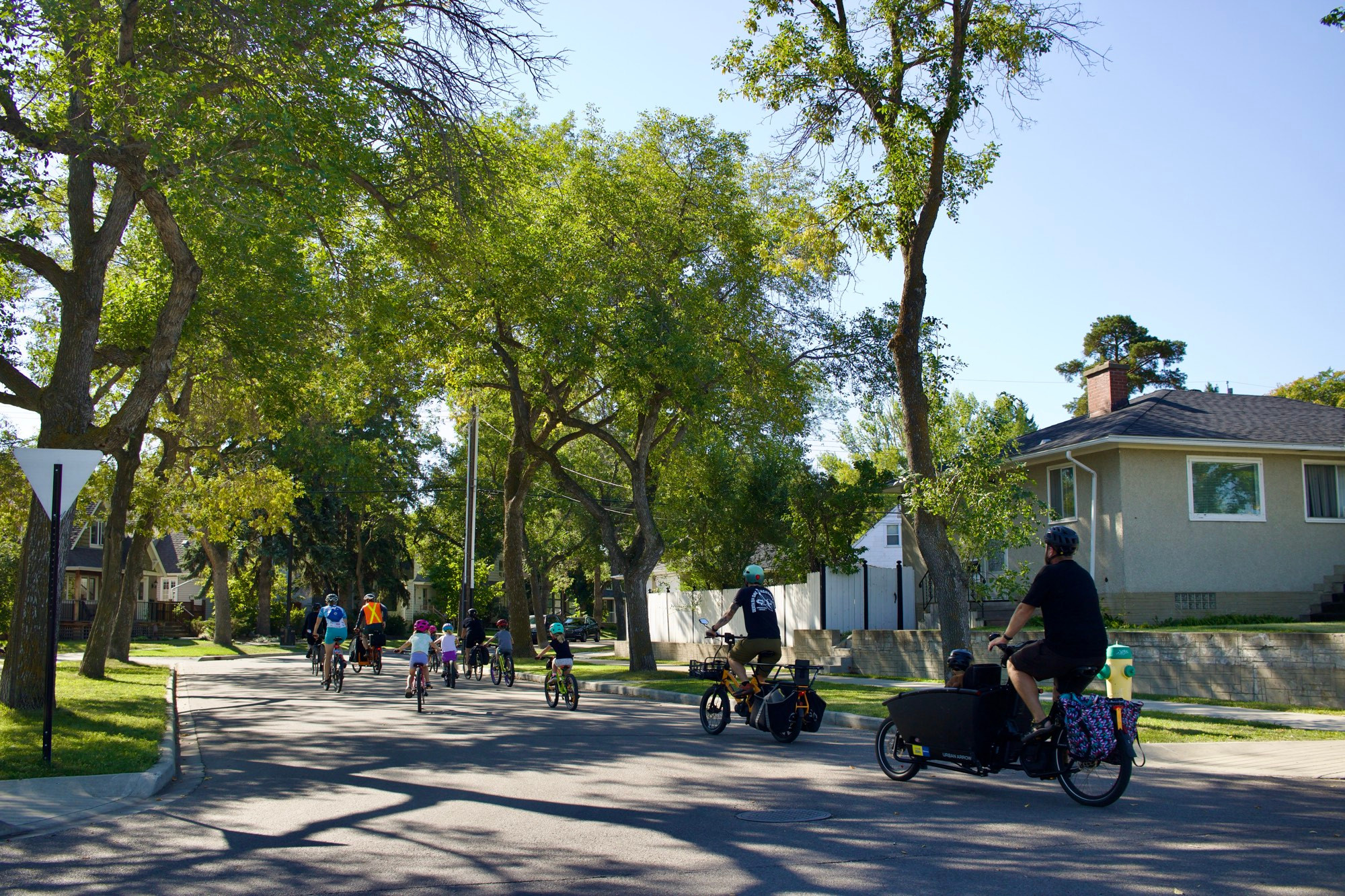Group of children and adults riding bikes. 