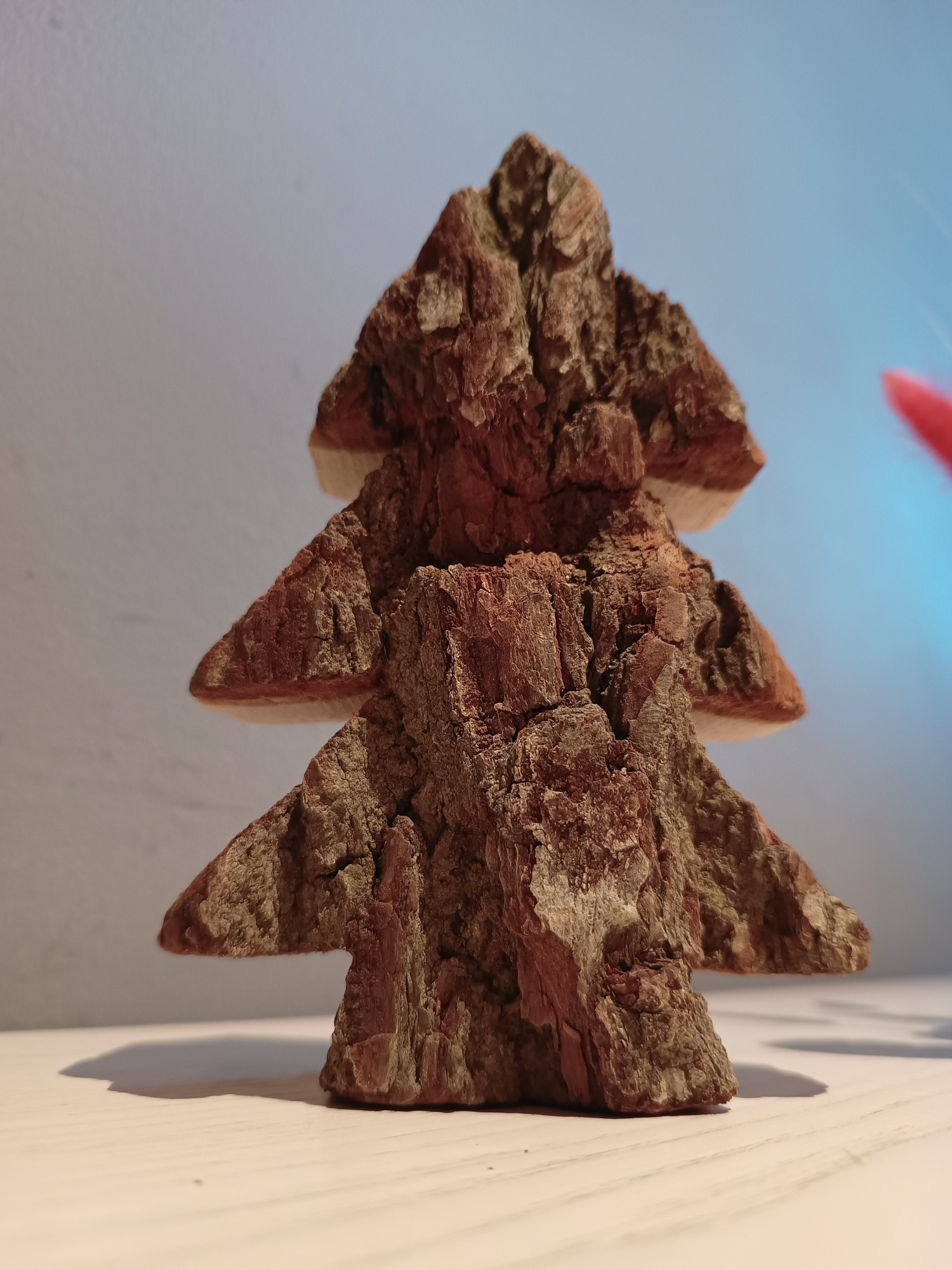 Tannenbaum / Weihnachtsbaum grob aus Holz ausgeschnitten. Zu sehen ist die Rindenseite.