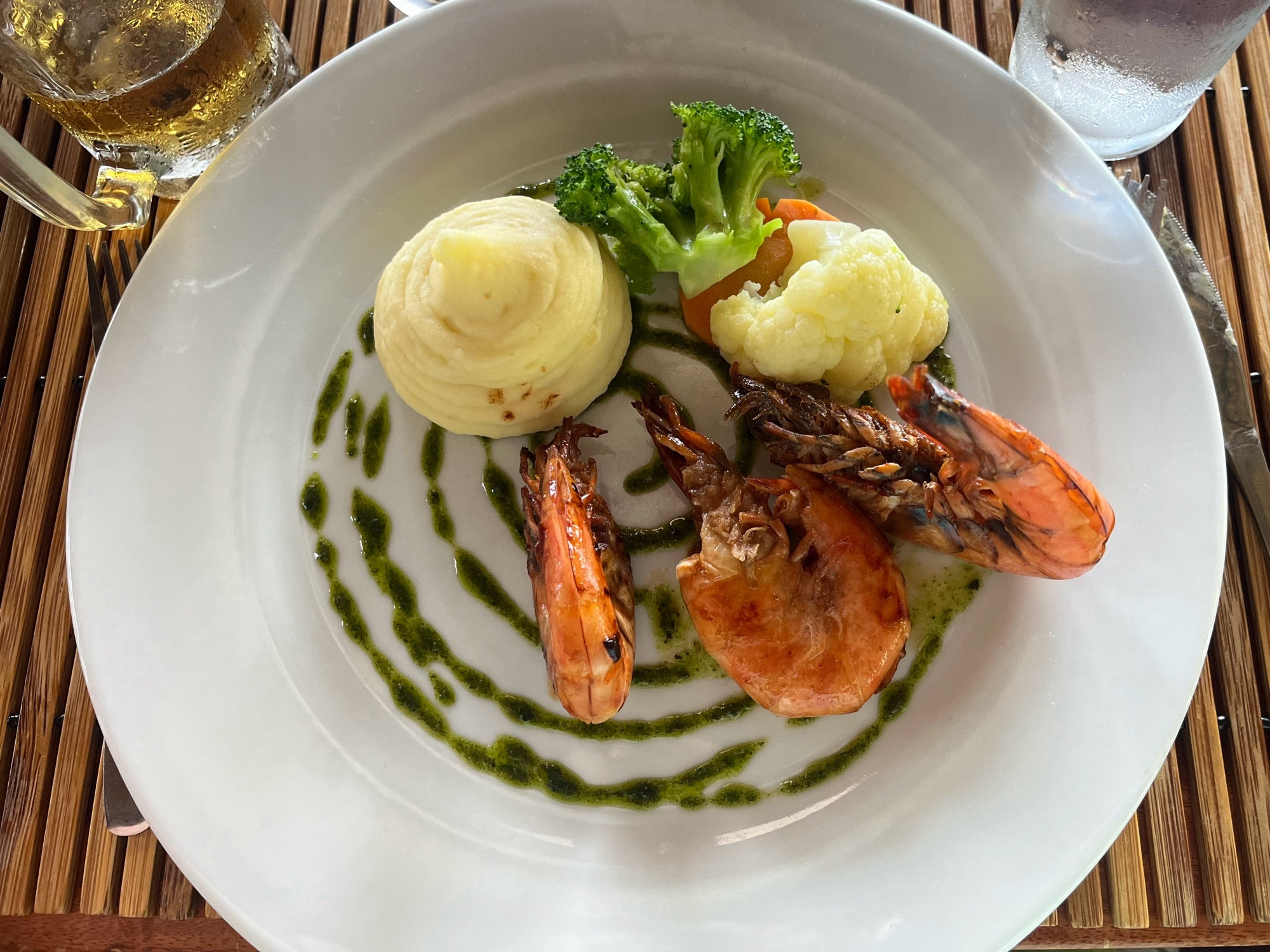 Plate with 3 large prawns a vegetable purée and some cauliflower and carrots