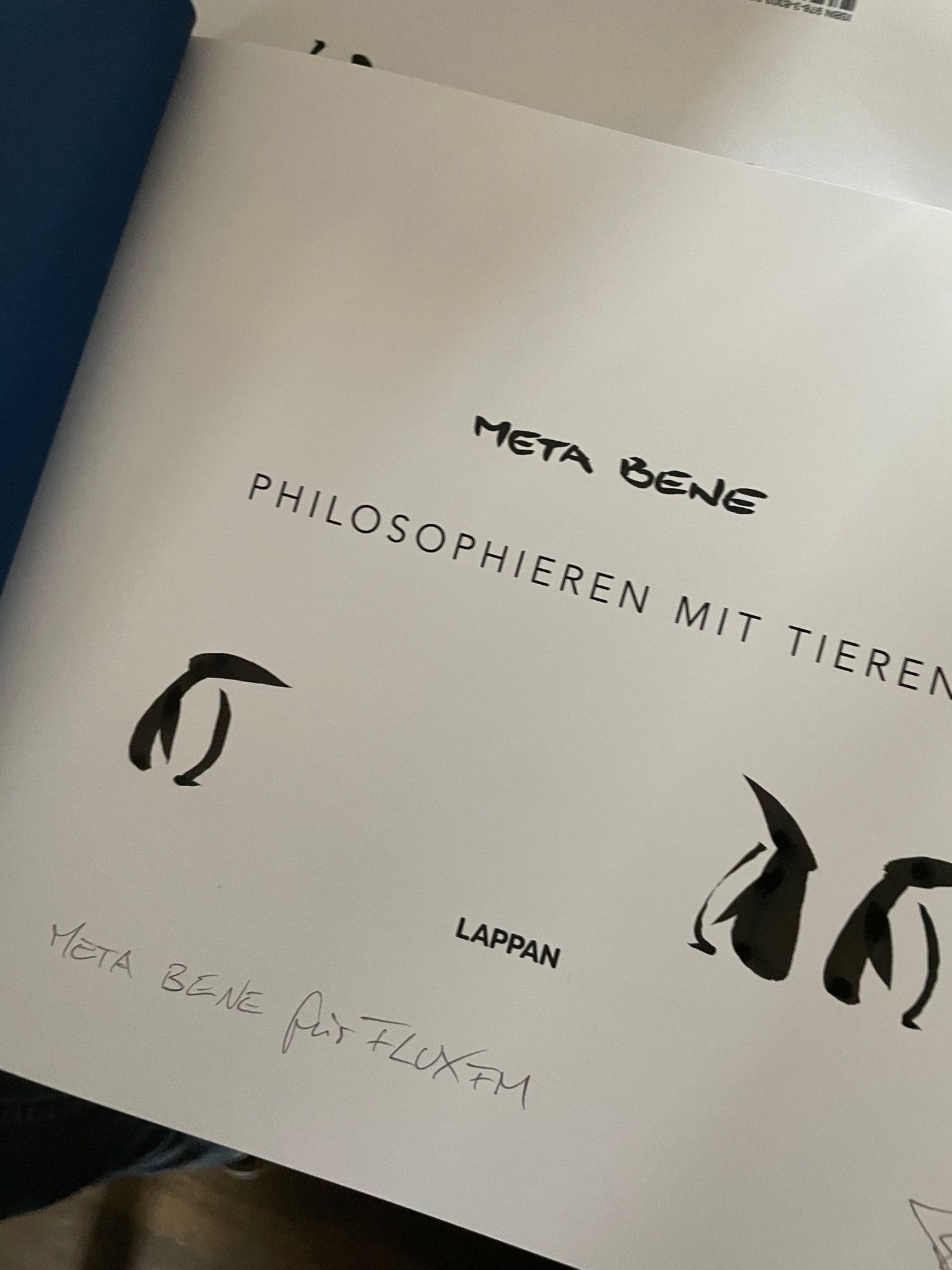 Aufgeschlagenes Buch "META BENE - Philosophieren mit Tieren", Zwischentitel mit Signatur und handgezeichneten Pinguinen