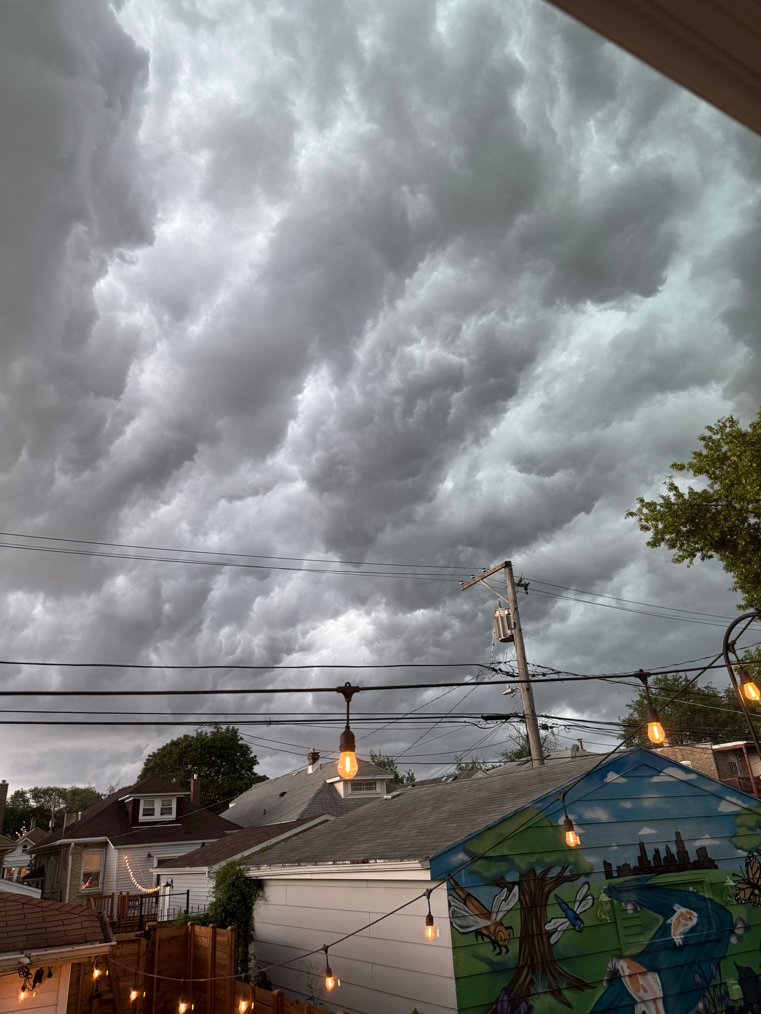 Crazy dark grey and light grey cloud formations over the garages and roofs of houses. 