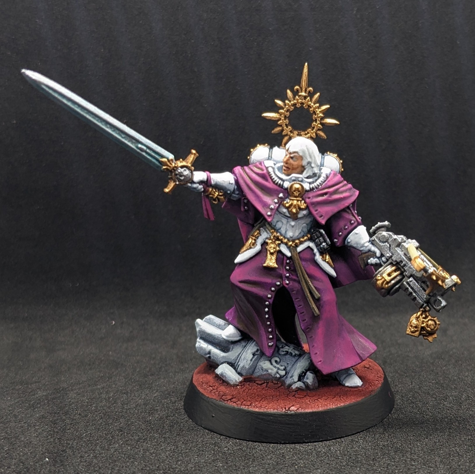 A Warhammer 40K Adepta Sororitas Canoness in white armour with purple robes