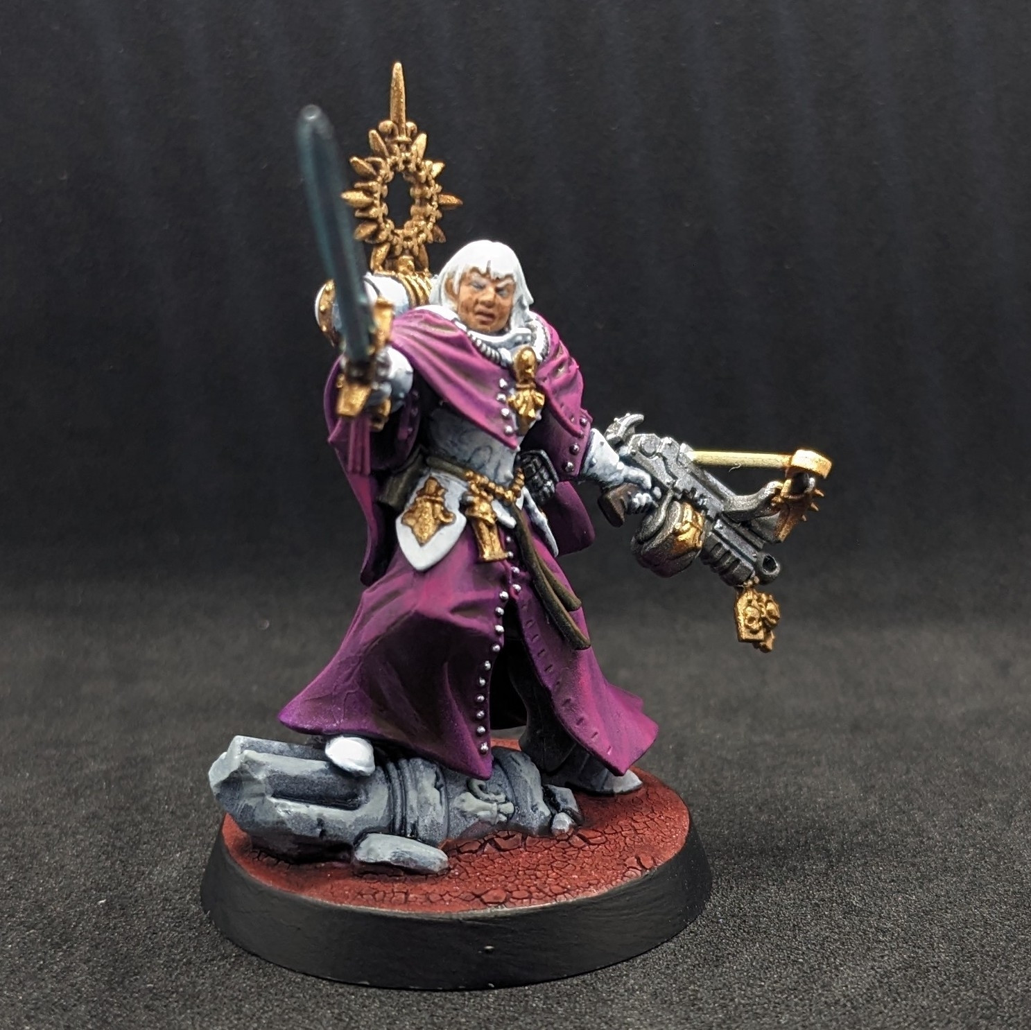 A Warhammer 40K Adepta Sororitas Canoness in white armour with purple robes, from the side