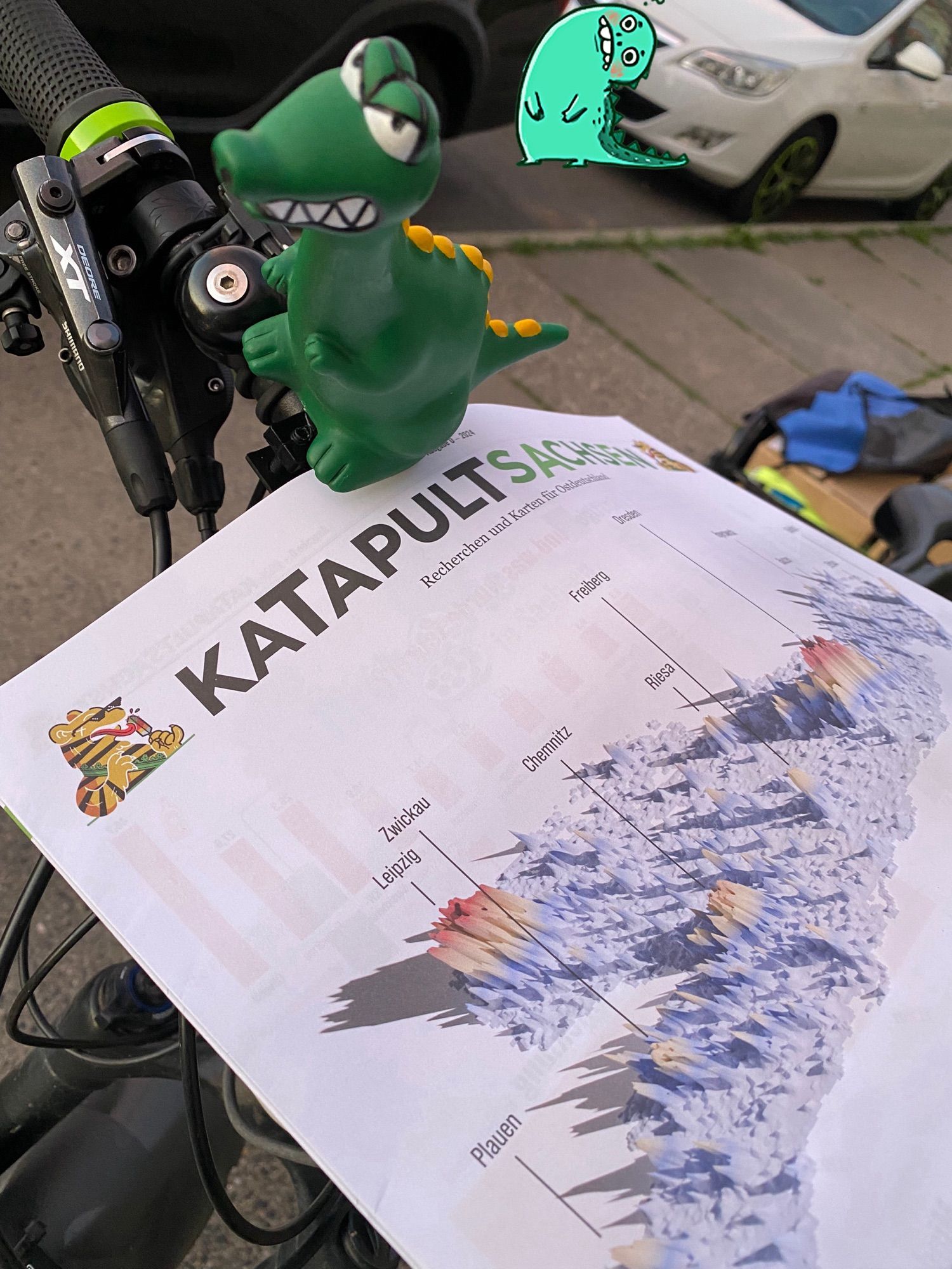 Katapult Sucksen mit dem kleinen Dino auf einem Fahrradlenker