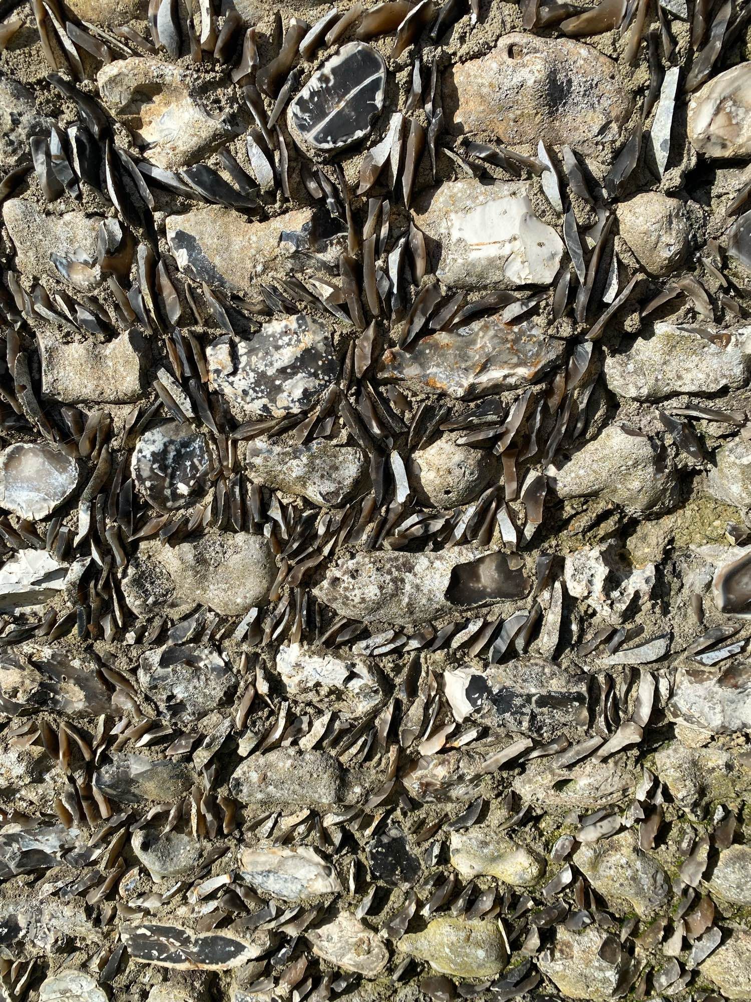 A detail shot of a wall made of large flints with smaller flint chips filling the gaps around them