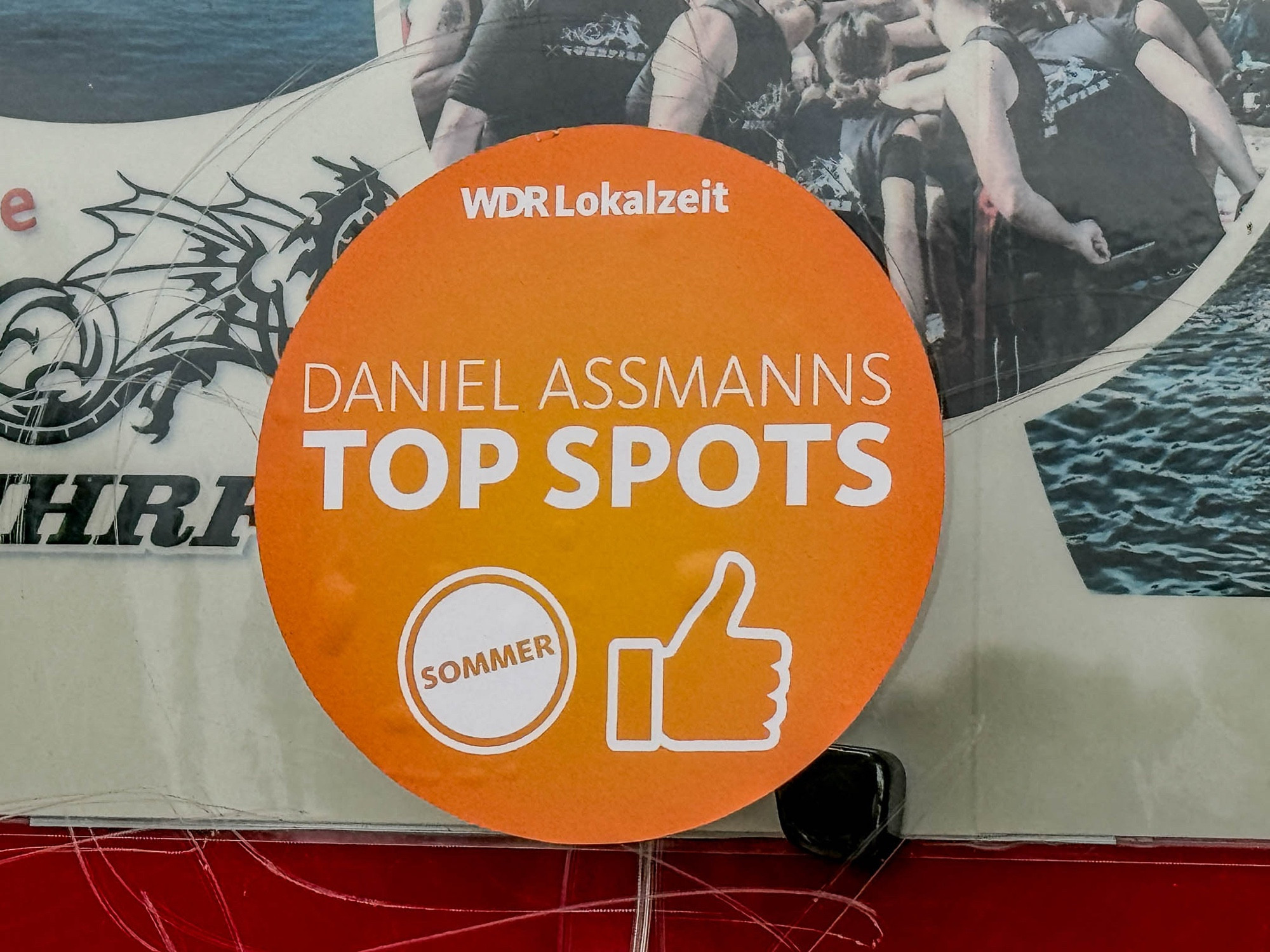 Ein orangefarbiger Aufkleber mit Aufschrift "Daniel Assmans Top Spots"