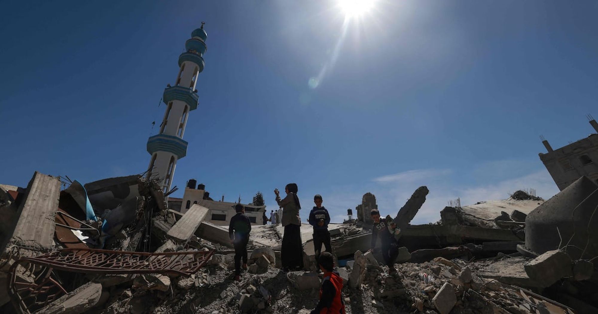 children in the rubble of a mosque destroyed by Apartheid Israel