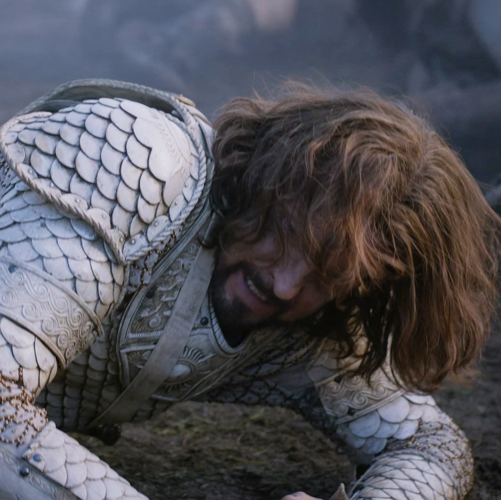 a screenshot of lloyd owen as elendil in the rings of power season 1 episode 6 where he is on the ground struggling to get to his feet