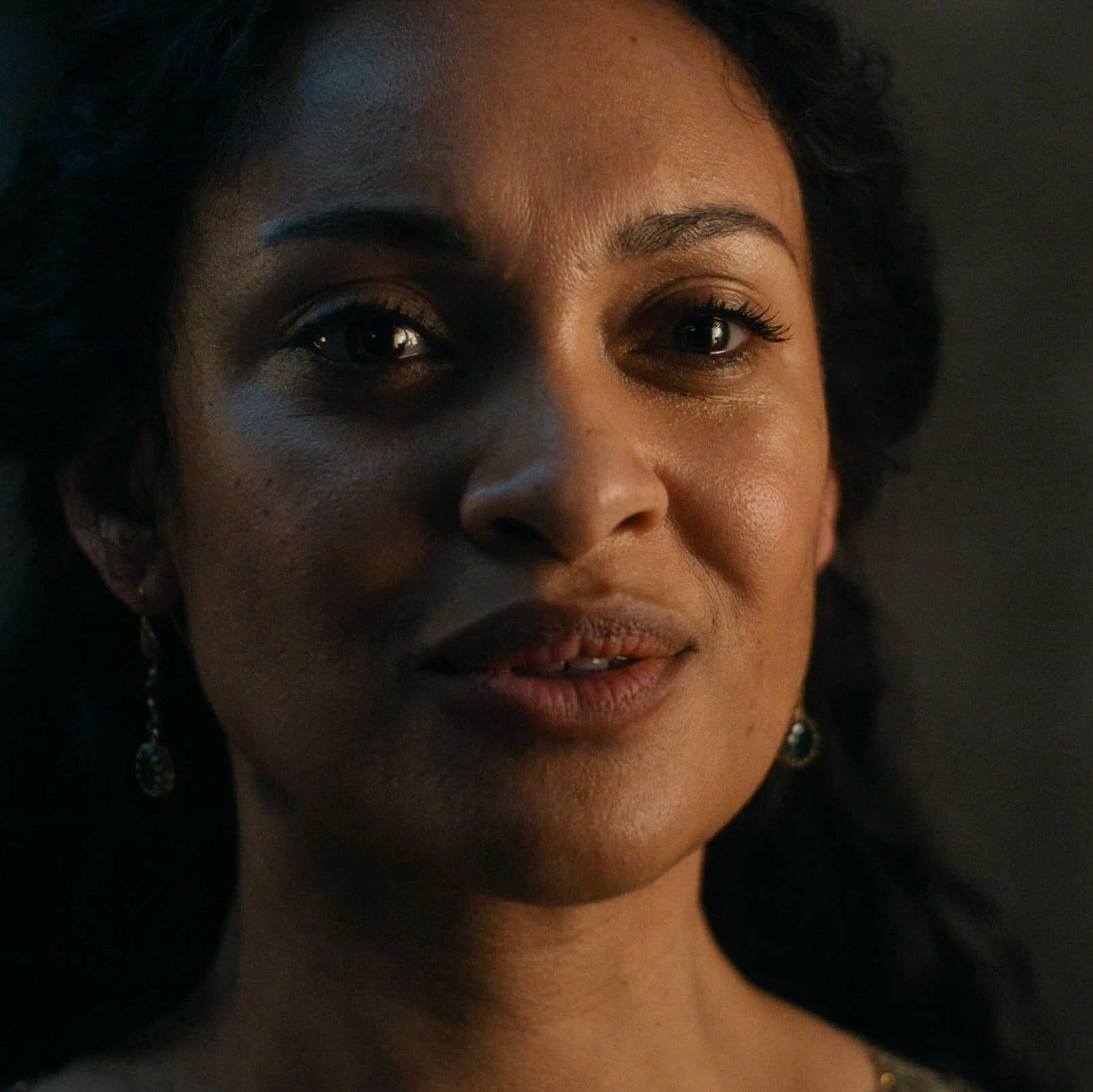 a close up screenshot of cynthia addai-robinson as tar-míriel, where she has a small forlon smile. From season 2 episode 8 of the rings of power.