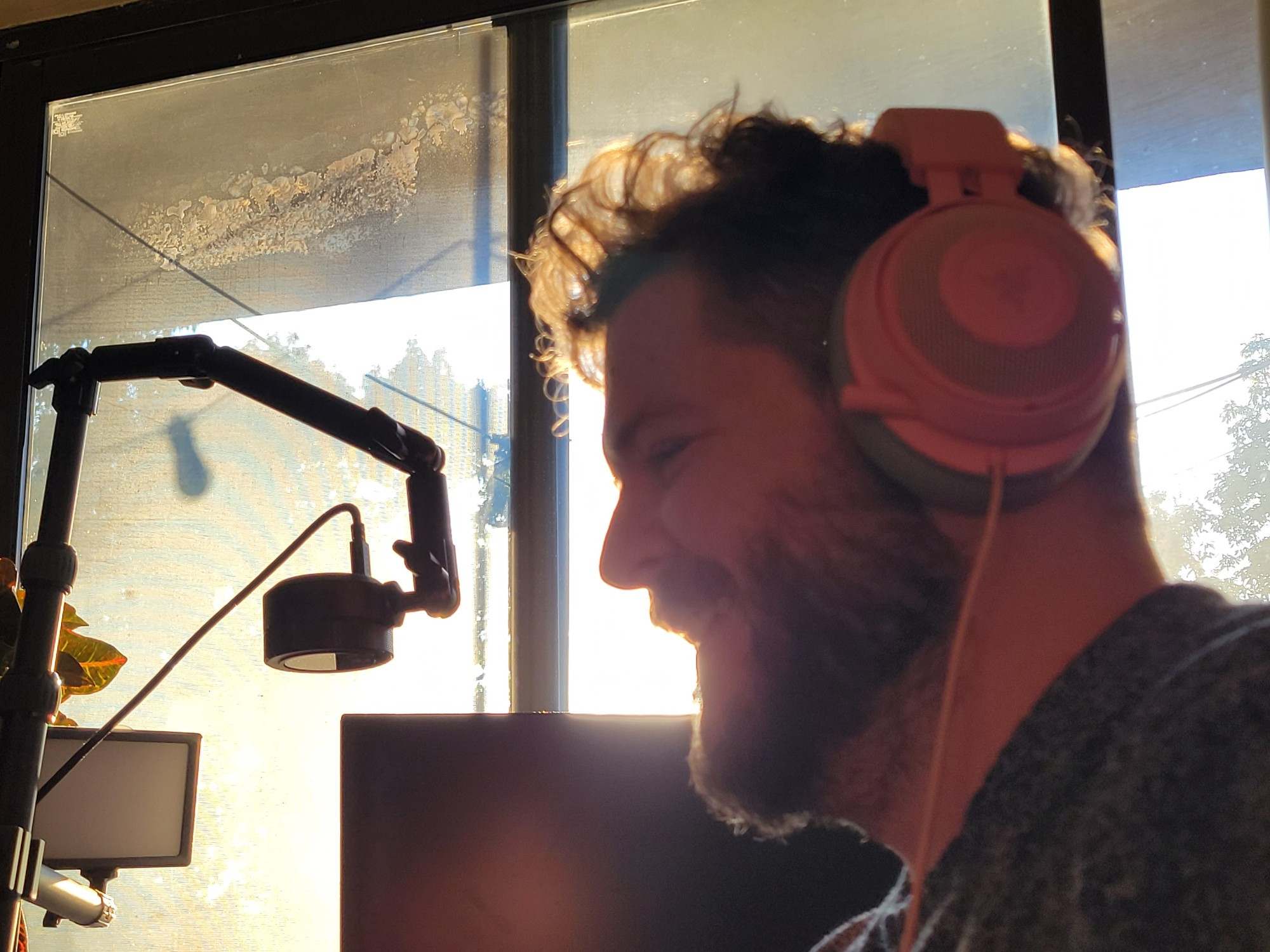 Sunset portrait shot of Benji smiling with headphones on. 