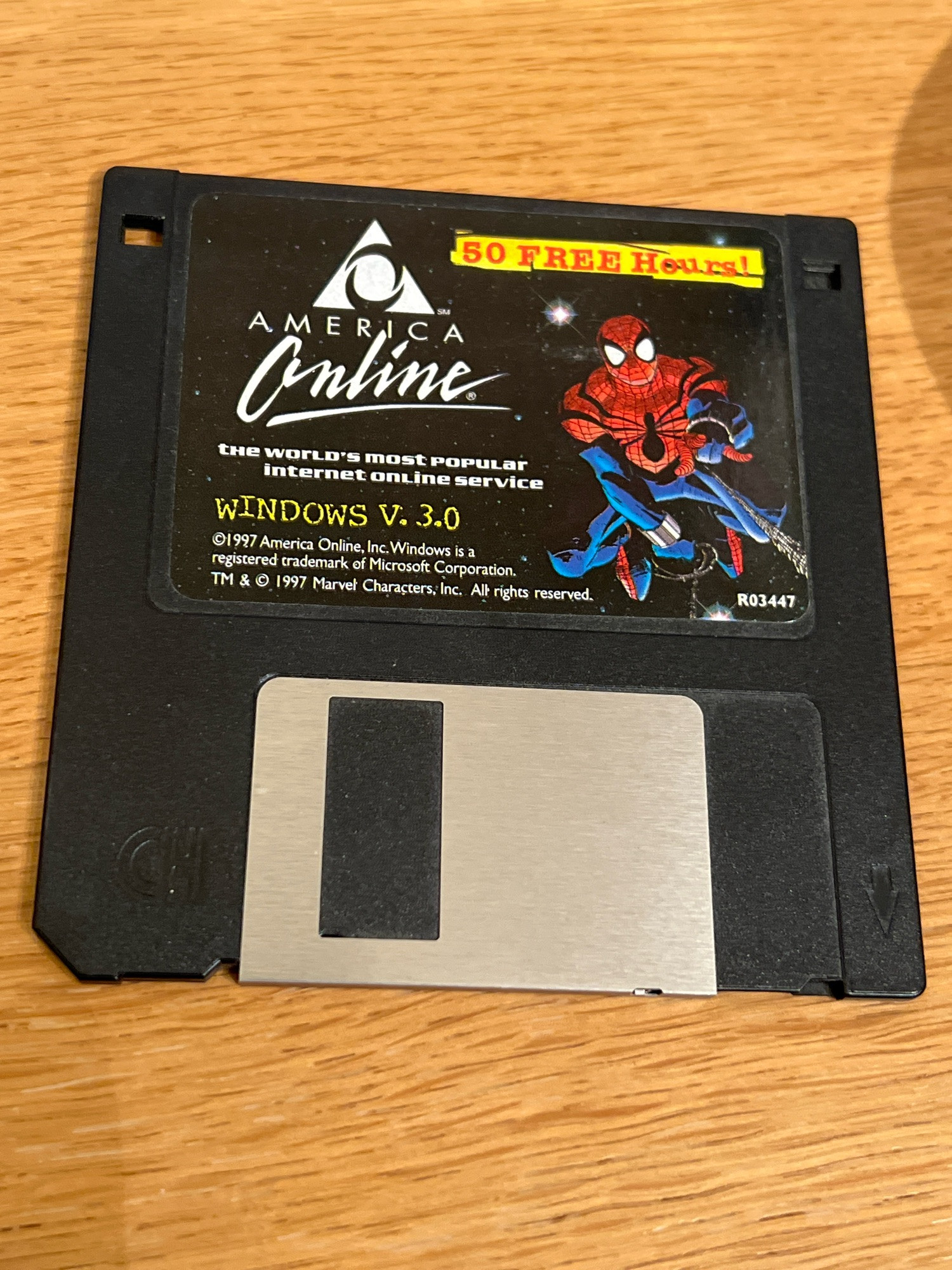 A 3.5 inch floppy disk on a desk offering 50 free hours of AOL time and containing a picture of spider-man in his Ben Reilly era redesigned costume. Art by John Romita Jr!