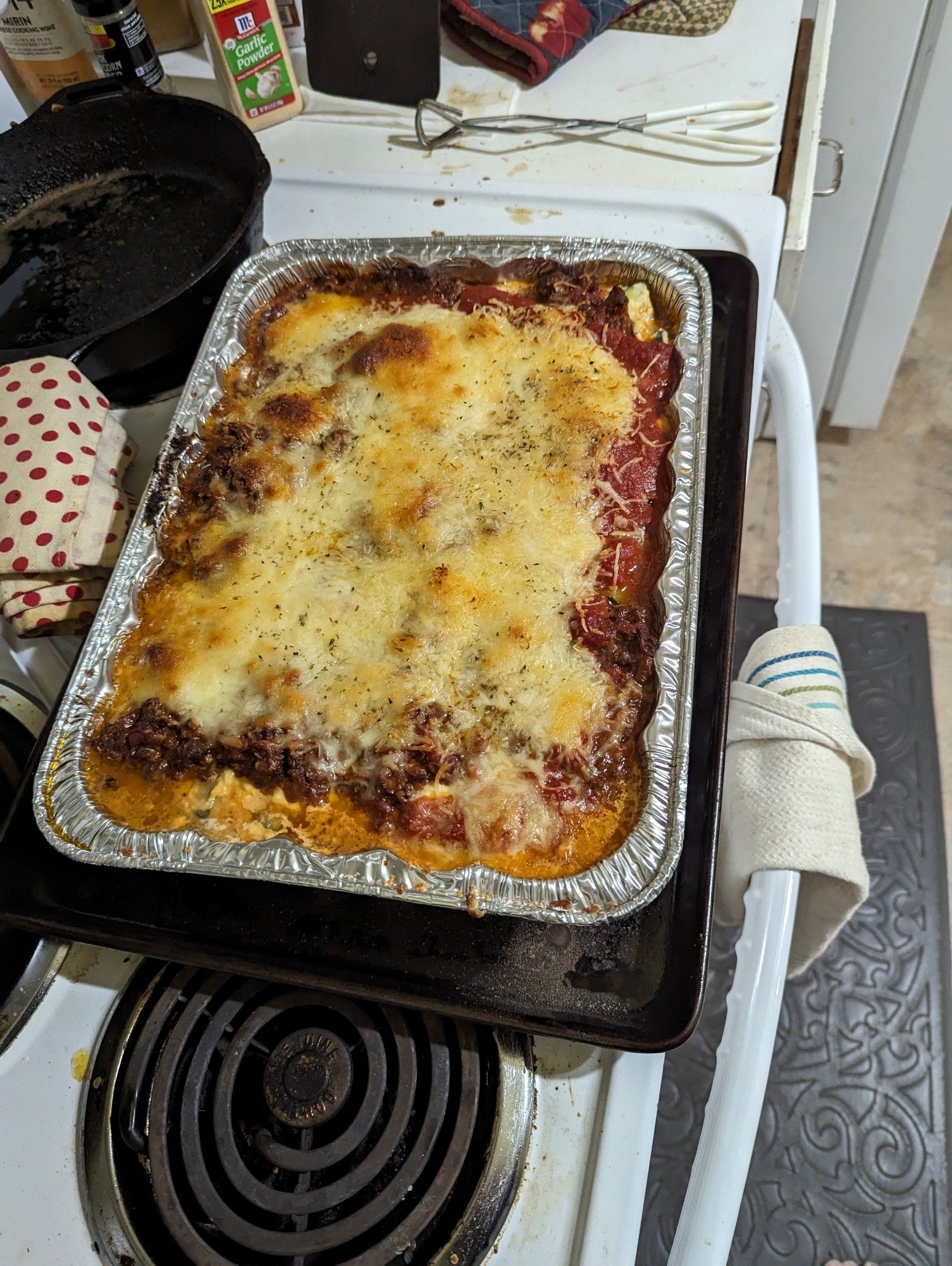 The finished lasagna, a lot of moisture pooling at the corners, the cheese beautifully melted