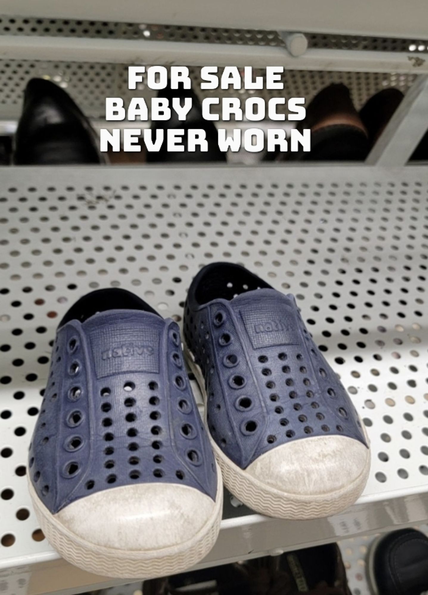 Picture of a pair of small Crocs sitting on a shelf, the text reads "For Sale: Baby Crocs. Never Worn"