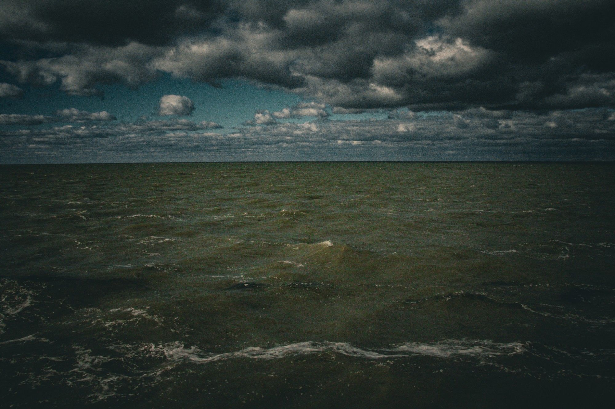 Choppy waters of a lake with dark clouds above.