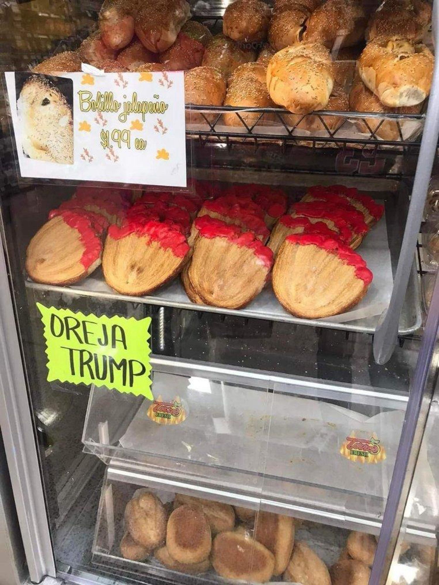 Pastry topped with red food coloring and a sign that reads “trump’s ear”