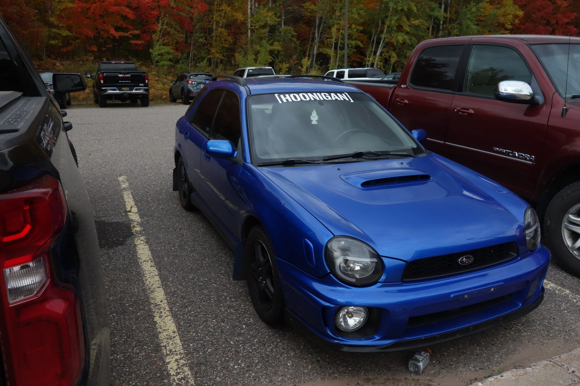 A world rally blue bugeye wrx wagon parked with a hoonigan banner 