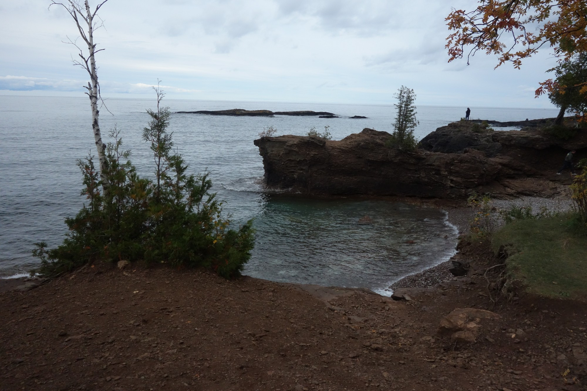 A cove on presque Isle in Marquette Michigan. The cove shows low rocky cliffs and a small island out into lake superior 