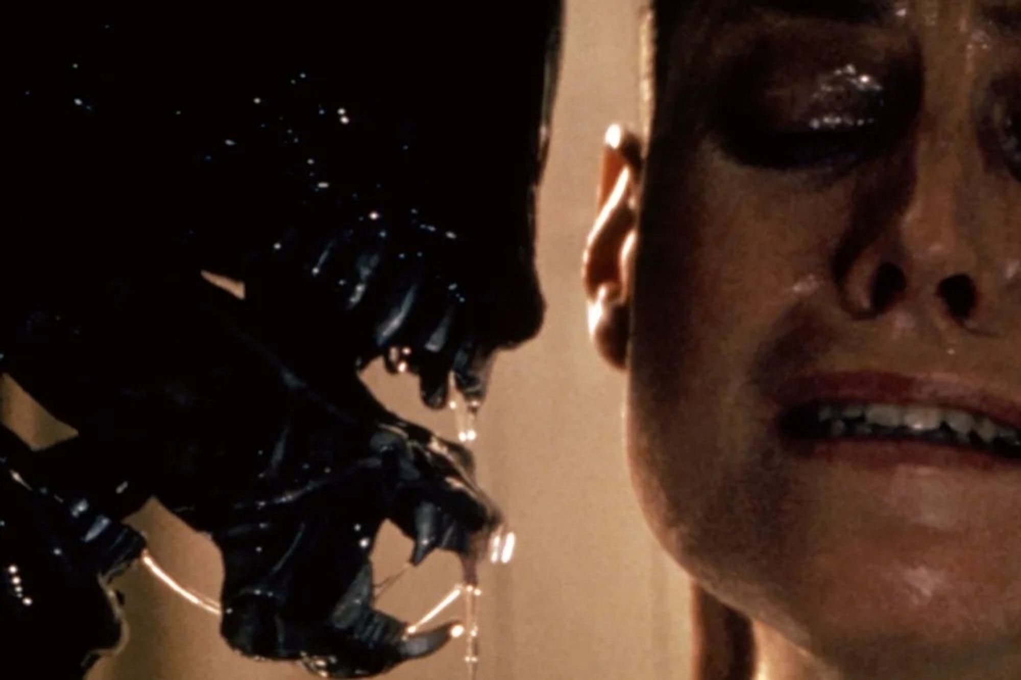 Close up image of Sigourney Weaver, as Ripley in Alien, with the Alien in her face, second mouth-tongue extended