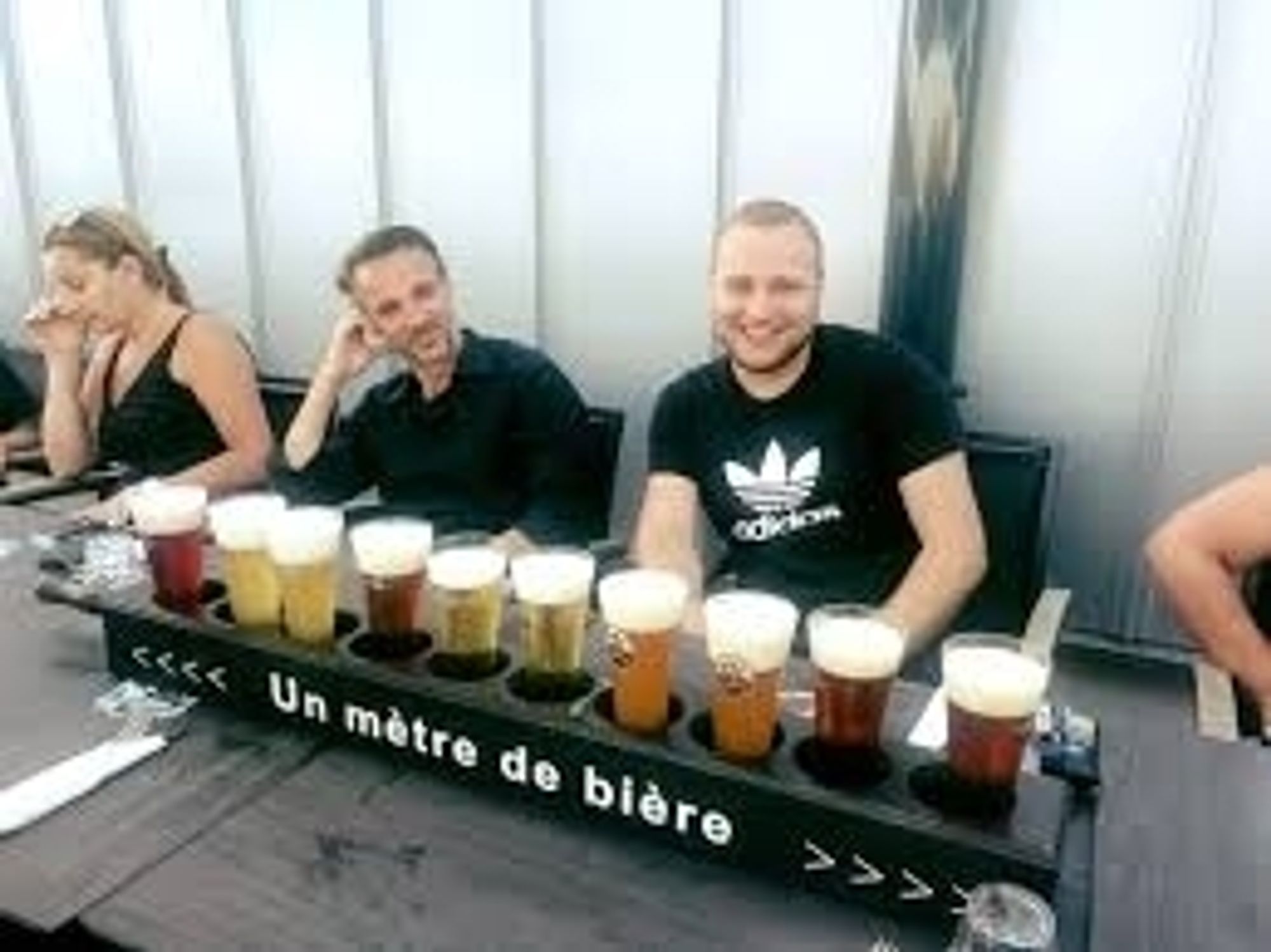 4 personnes sont assises devant 1 mètre de pintes de bière