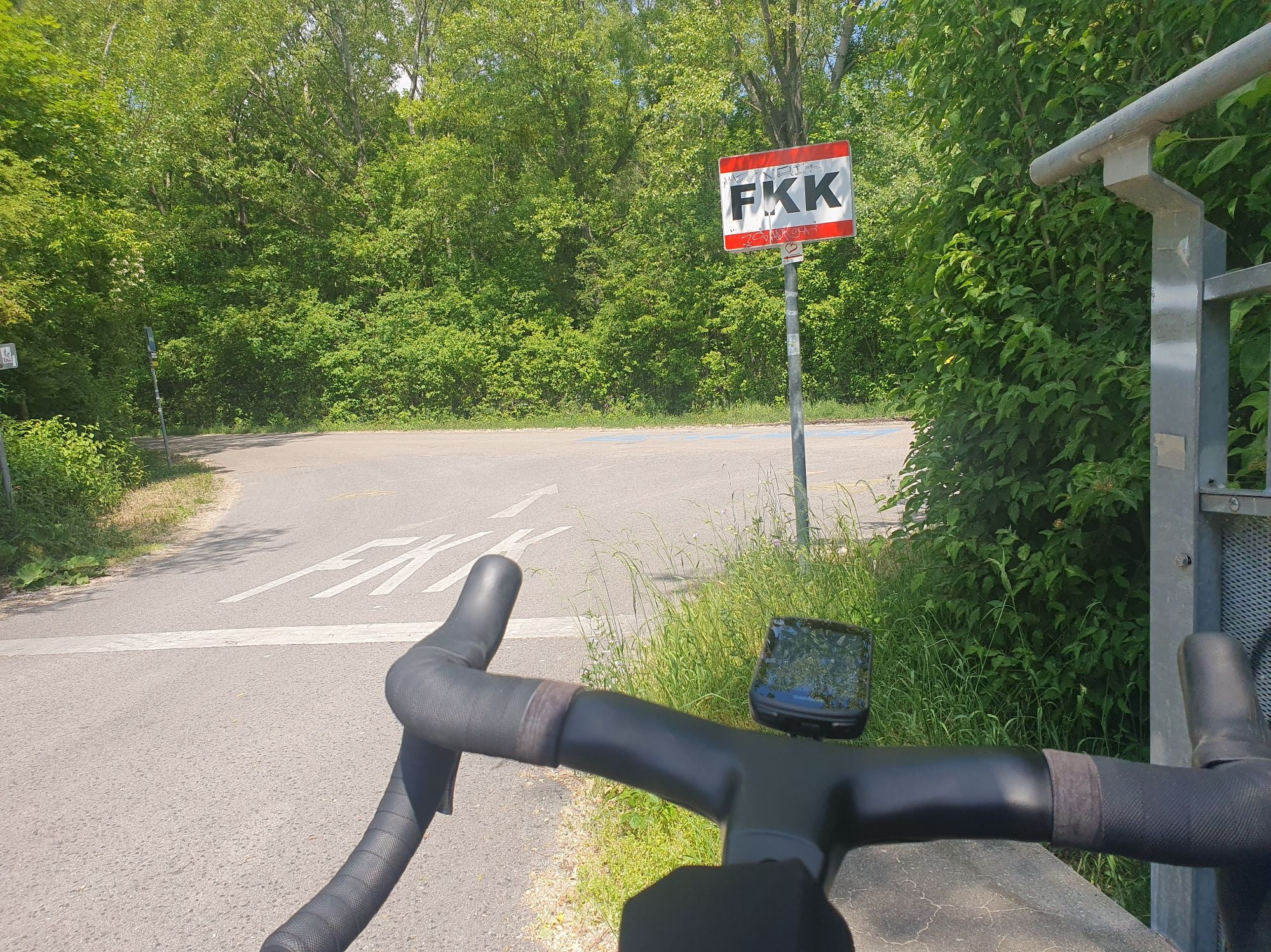 Radweg, der in einen FKK-Bereich einmündet.