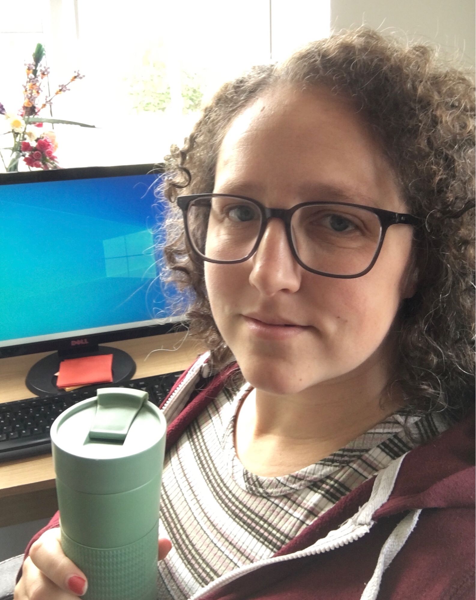 Selfie at my desk, looking tired, travel mug in hand