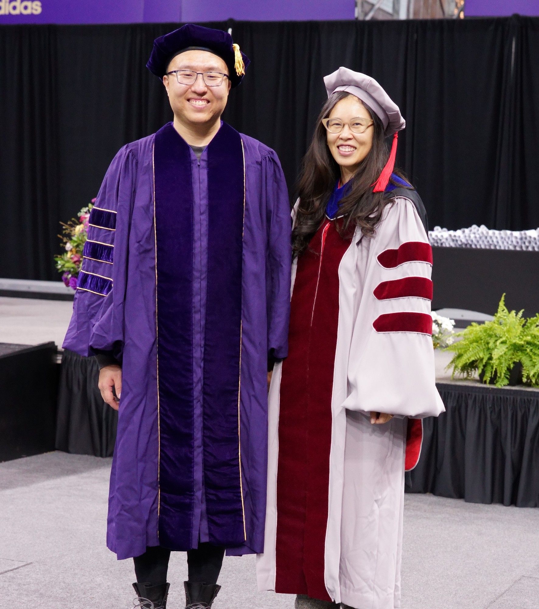 Jim and me in our PhD regalia smiling at the camera