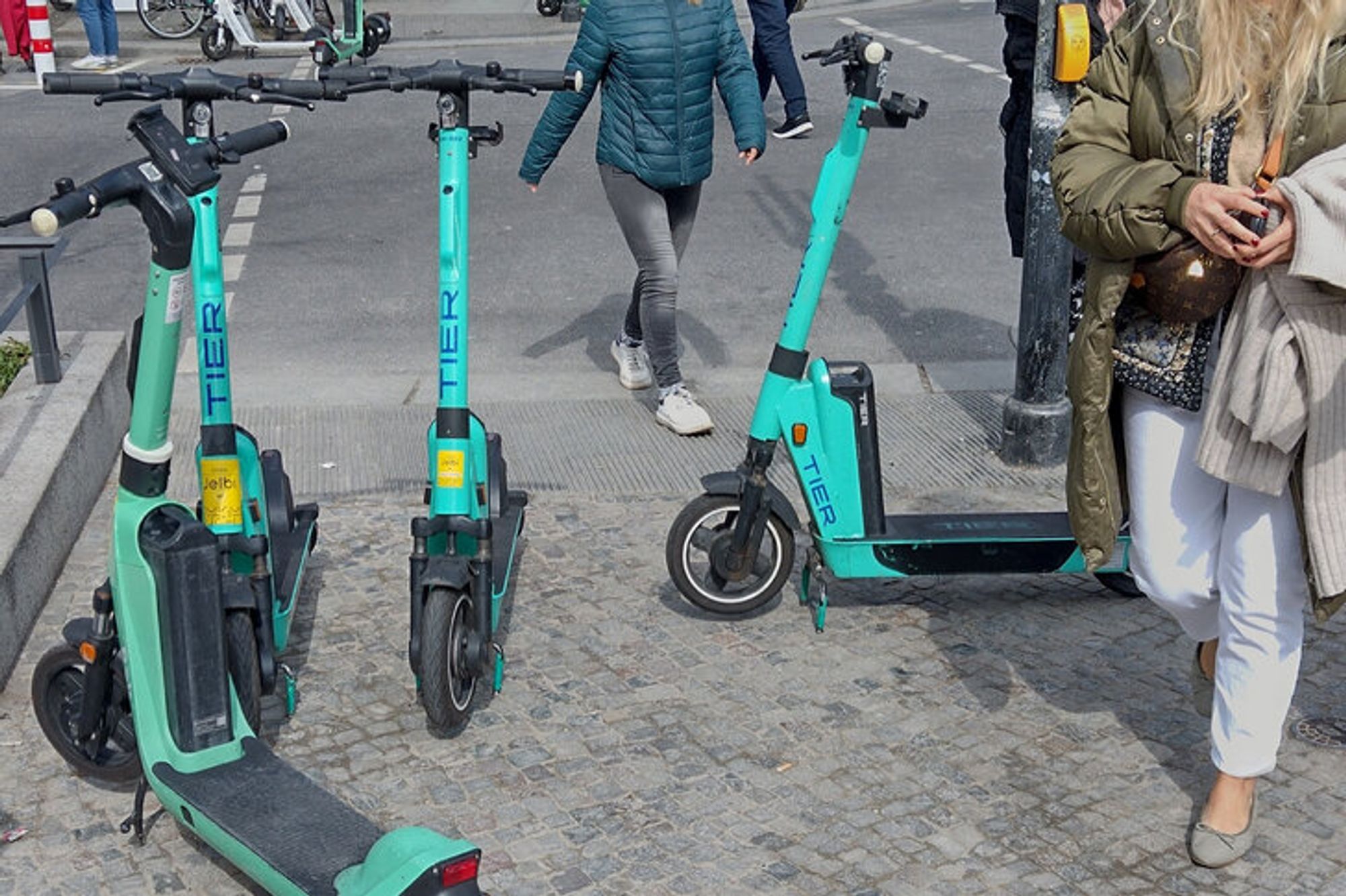 E-Scooter stehen herum, Gehende müssen über und um sie herum laufen