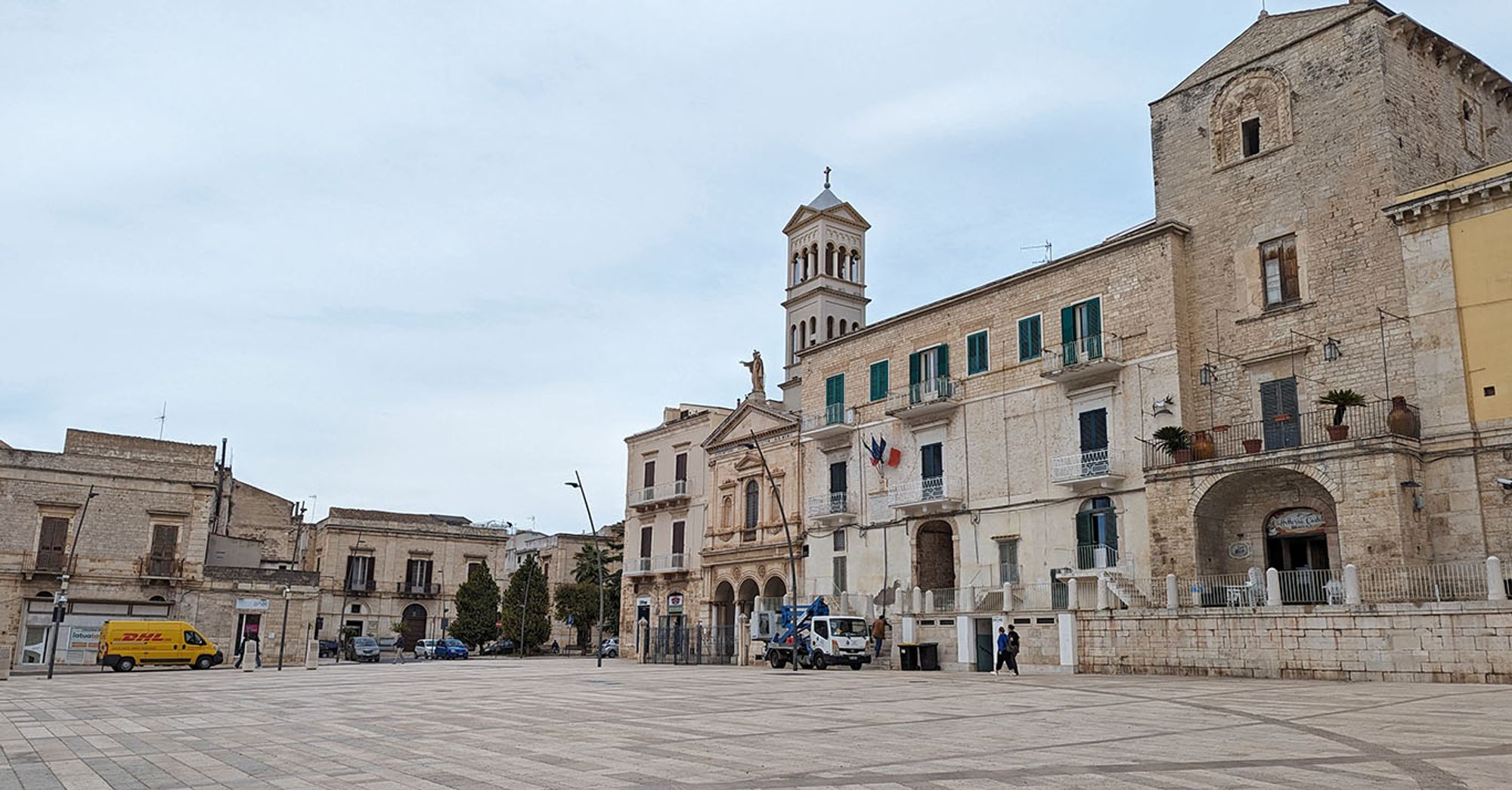 The ample square dwarfs the two and three-storey buildings around it, including a towered 20th century church and the remains of the medieval castle.