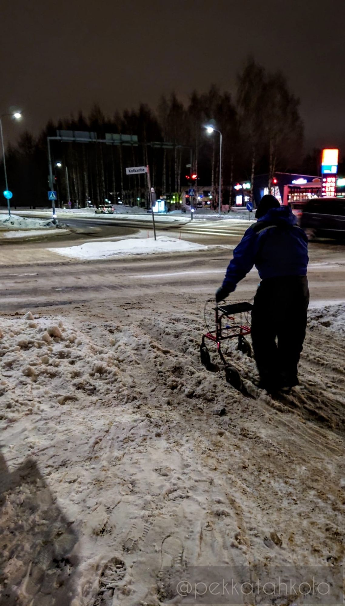 A person with a mobility walker stuck in badly maintained path with slushy snow pushed from the drive lanes.