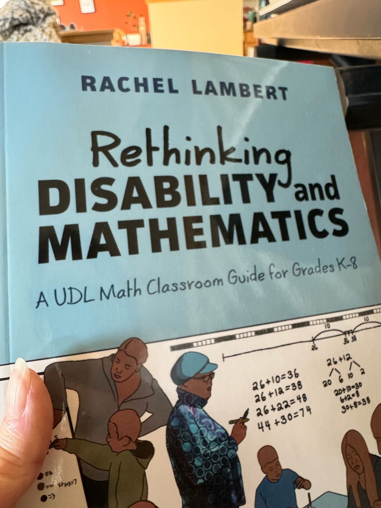 Cover of book “Rethinking Disability and Mathematics: A UDL math classroom guide for grades K-8” by Dr Rachel Lambert. A beautiful scene on the cover of students working together with adults, solving math problems with manipulatives and talking about/recording different strategies on the board.