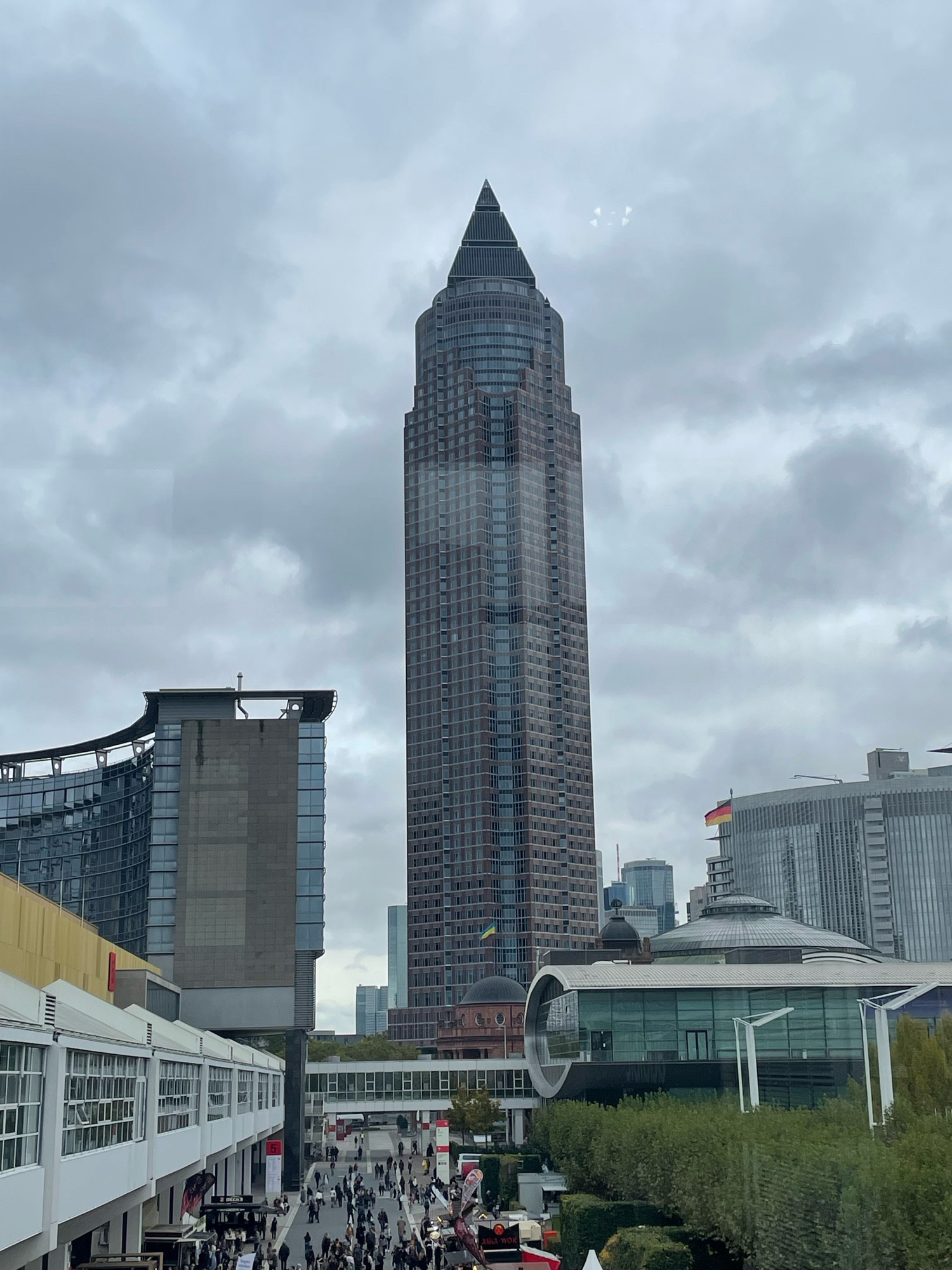 Foto von der Frankfurter Buchmesse, Blick auf einen Teil der Agora, mit sehr vielen Menschen, im Hintergrund der Messeturm