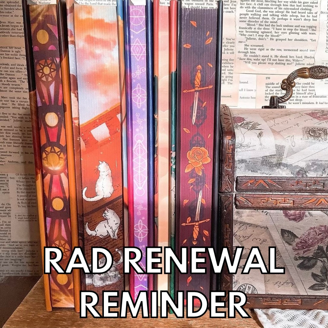 A photo of five printed edges standing next to a floral letter chest. The books are on a wooden surface with the wall behind them made up of book pages. The edges consist of stained glass windows, cats on a boat, glowing pink demonic sigils, orange-peach sunset clouds, and red edges with flowers and daggers from left to right. Text at the bottom reads "RAD Renewal Reminder" in all caps white font with a black outline.