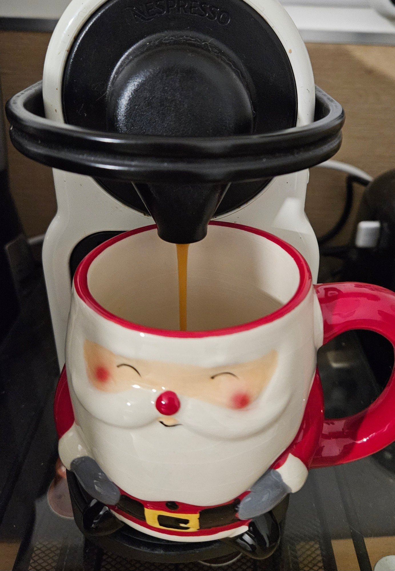 Café expresso qui coule dans une tasse Père Noël. Petite référence au Secrweet Santa 2023.