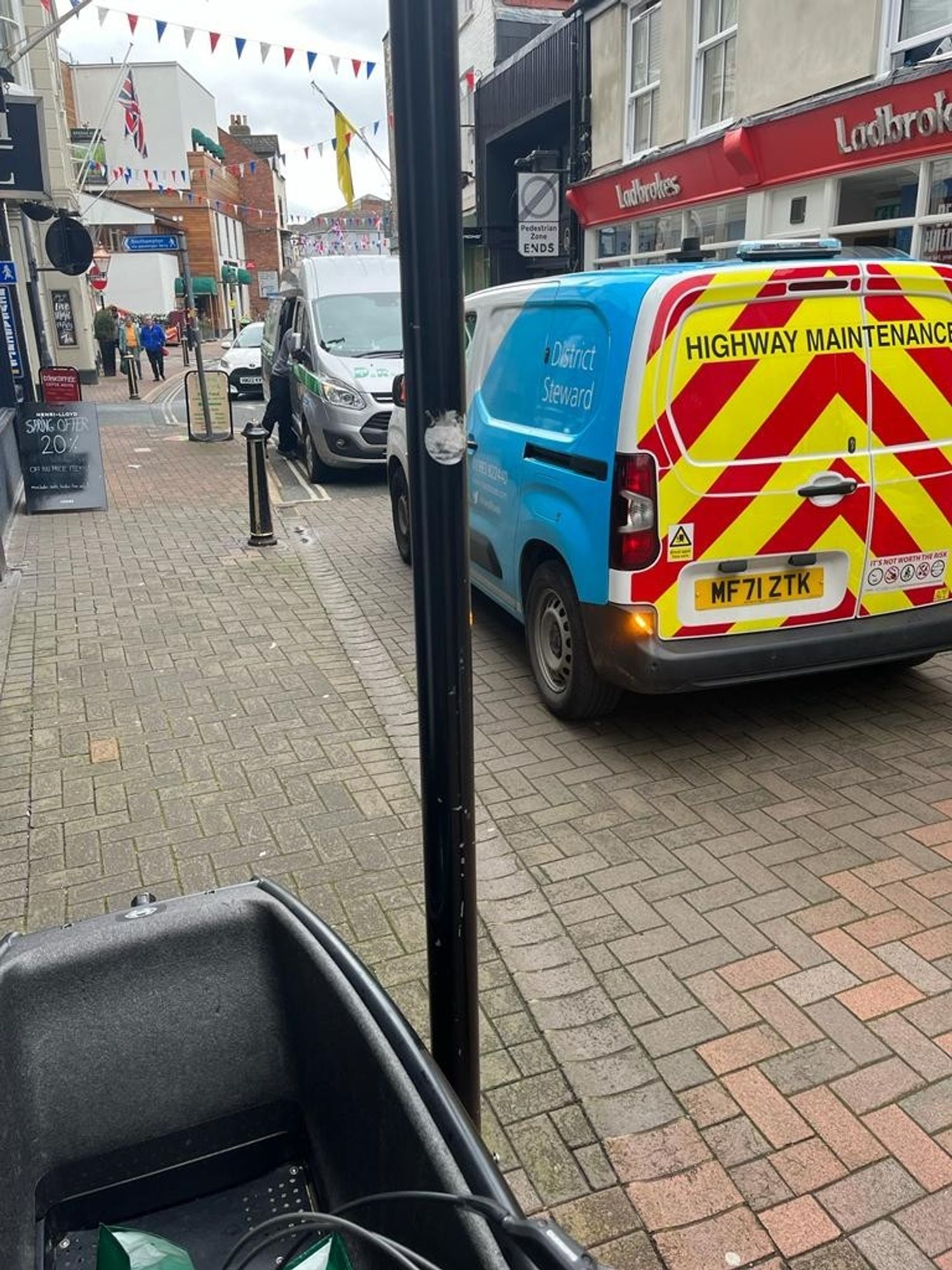 an island roads district steward on the pedestrianised section of Cowes High Street blocked by a van unloading whilst parked facing the wrong way down a one way street just before the pedestrianised section