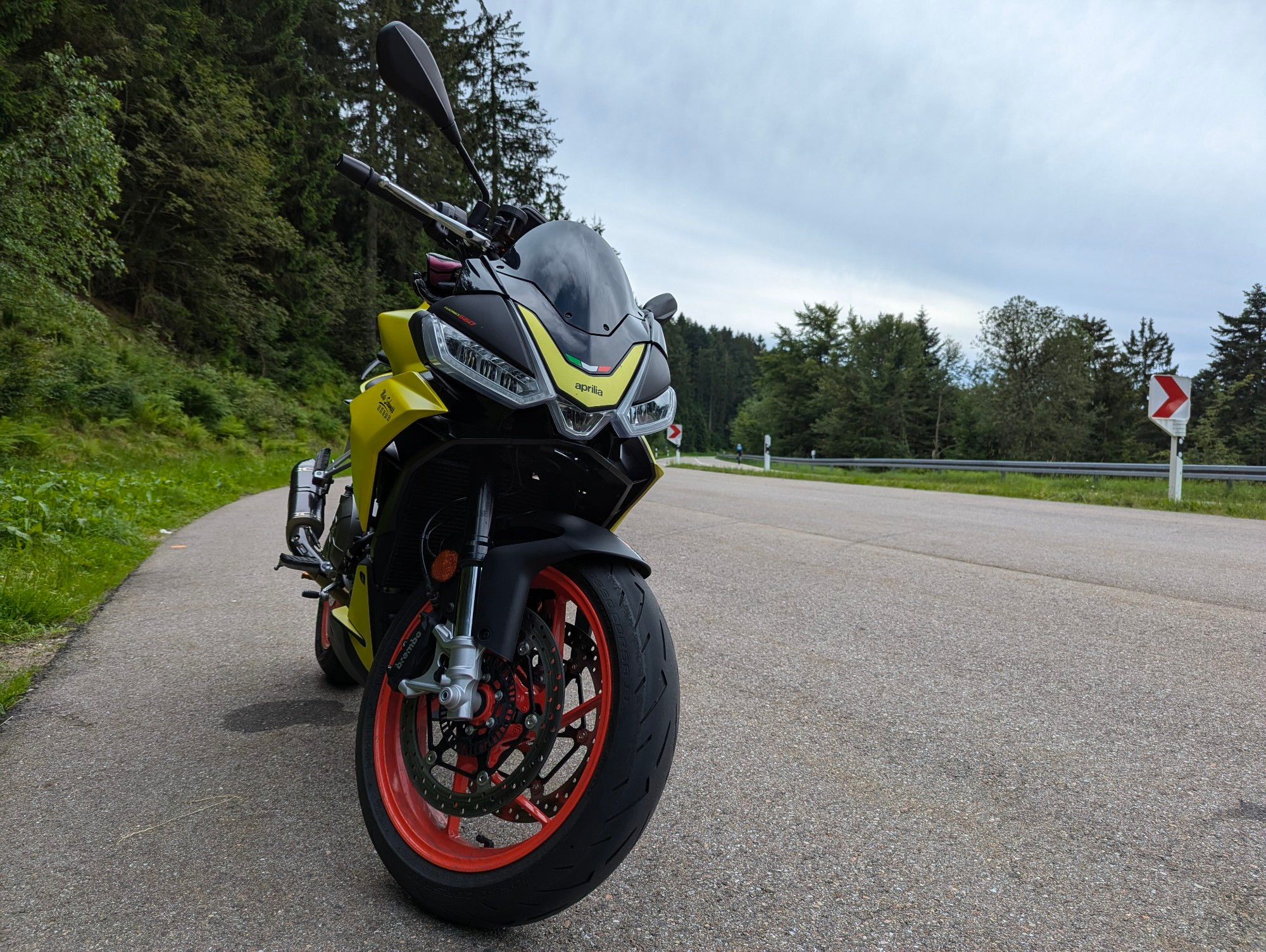 A yellow Aprilia on the side of the road